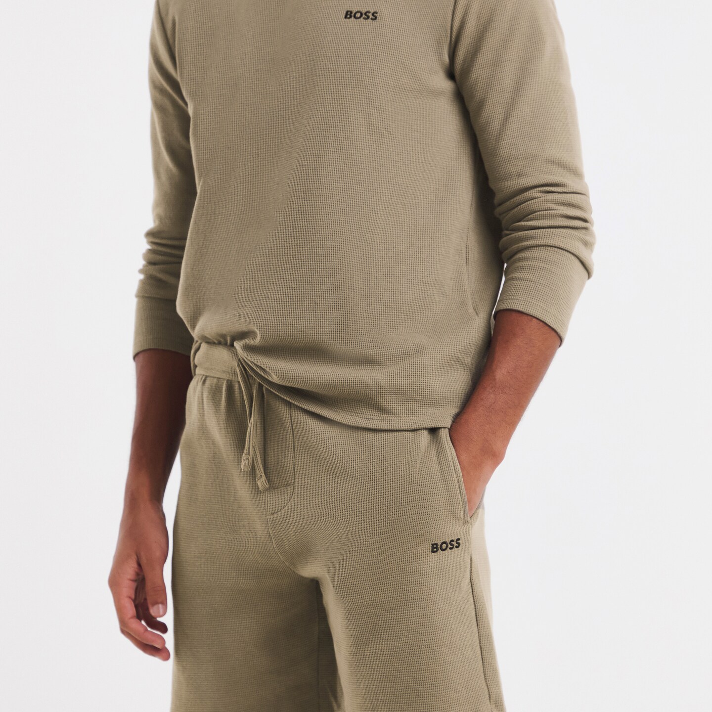 Model is wearing a brown BOSS long sleeve waffle lounge hoodie with a pair of brown BOSS waffle lounge short.
