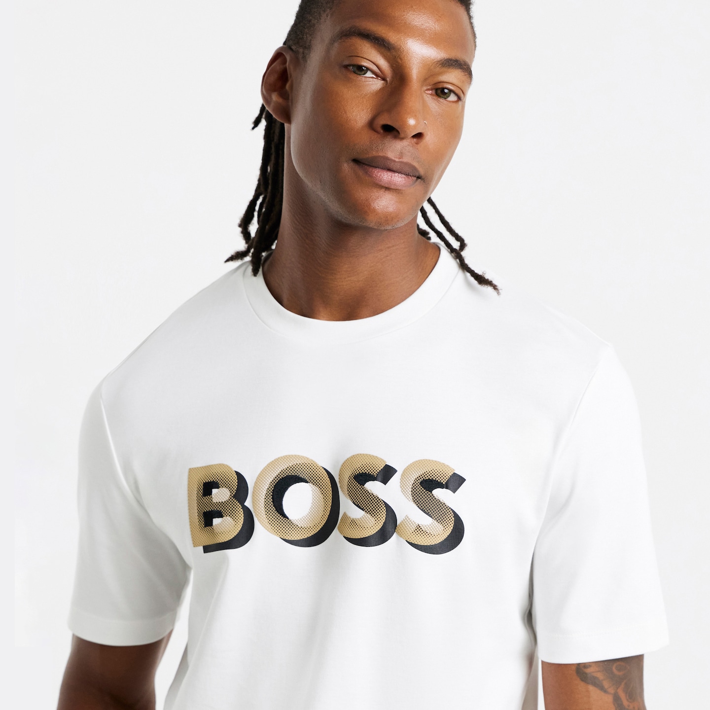 Model is wearing a white BOSS short sleeve graphic logo t-shirt.