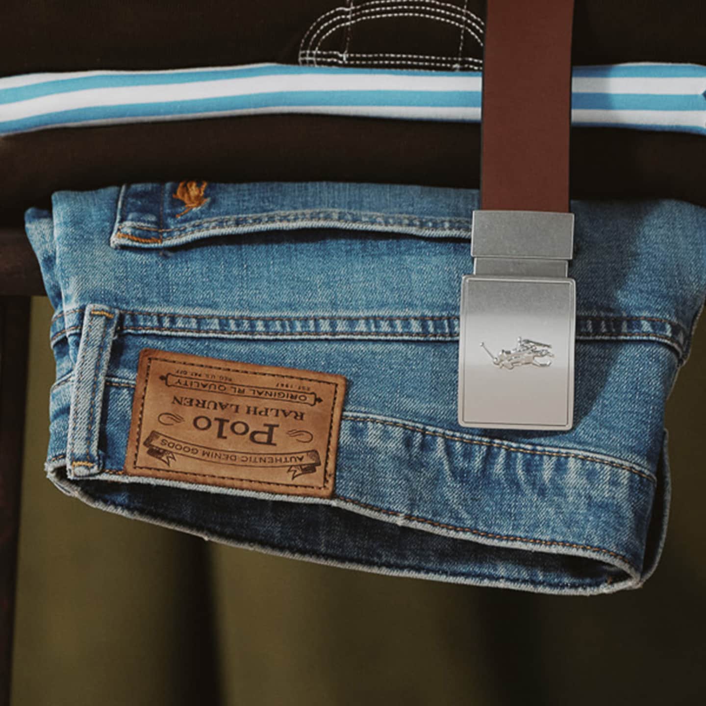 A pile of Polo Ralph Lauren items including jeans, shirt, sweatshirt and a belt.