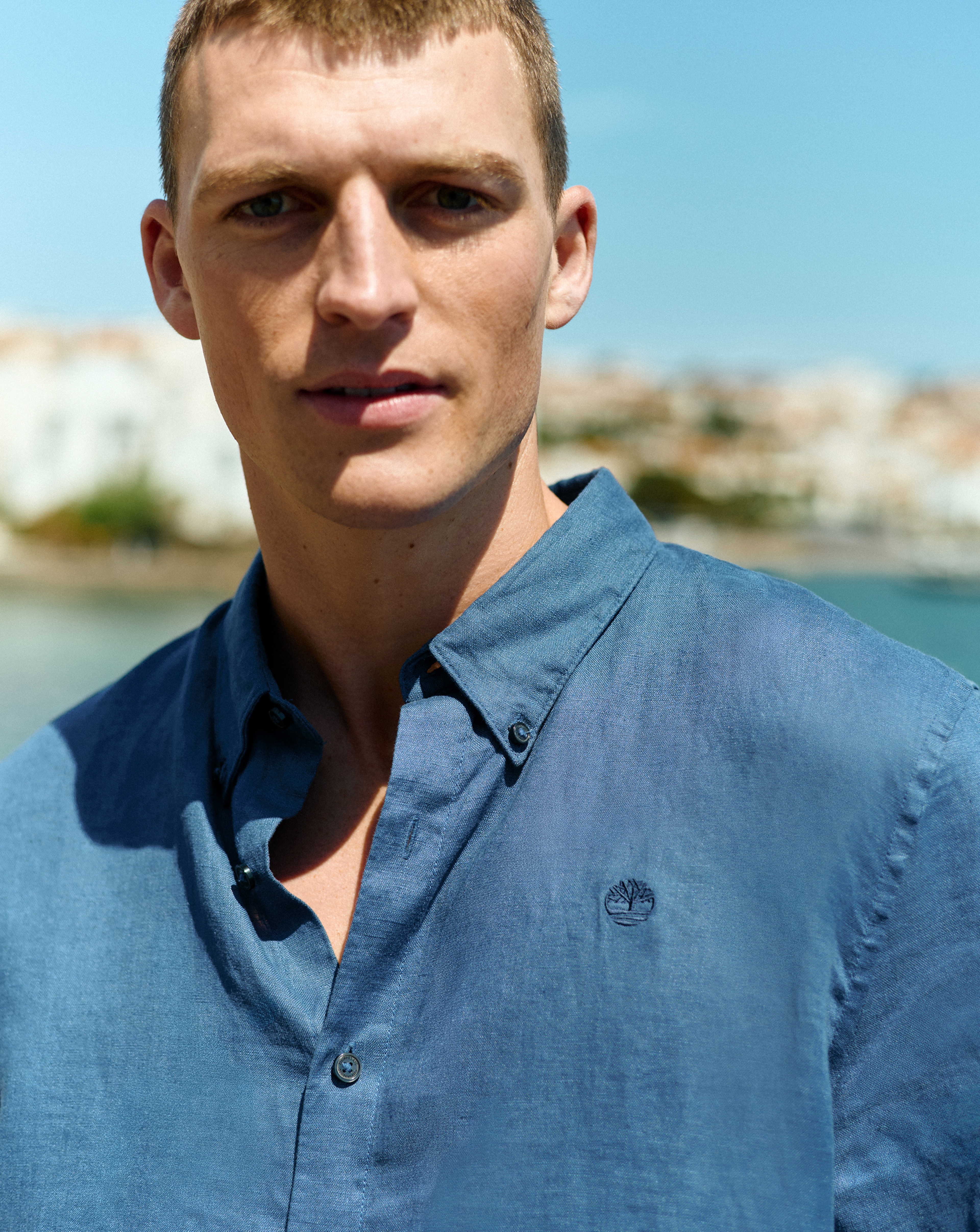 Model wears a blue Timberland linen short sleeve shirt.
