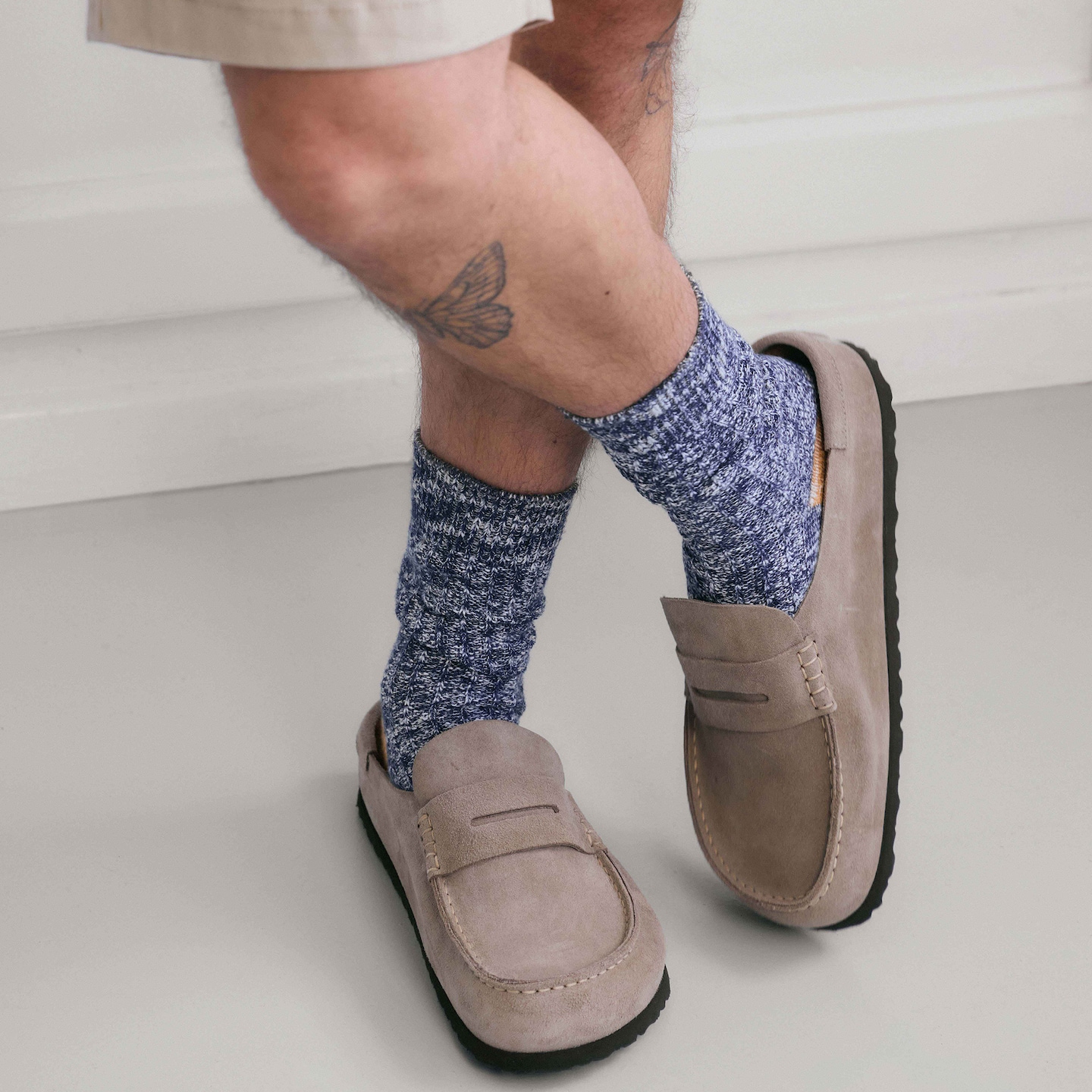 Model is wearing a pair of Birkenstock Classic Suede Naples loafers.