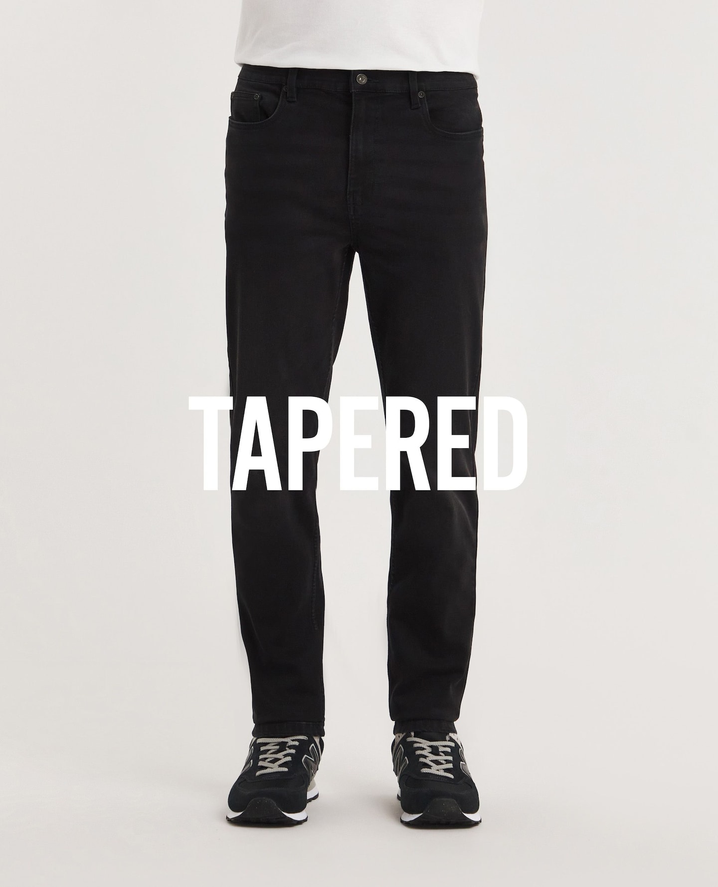 Close up image of a pair of black tapered fit jeans