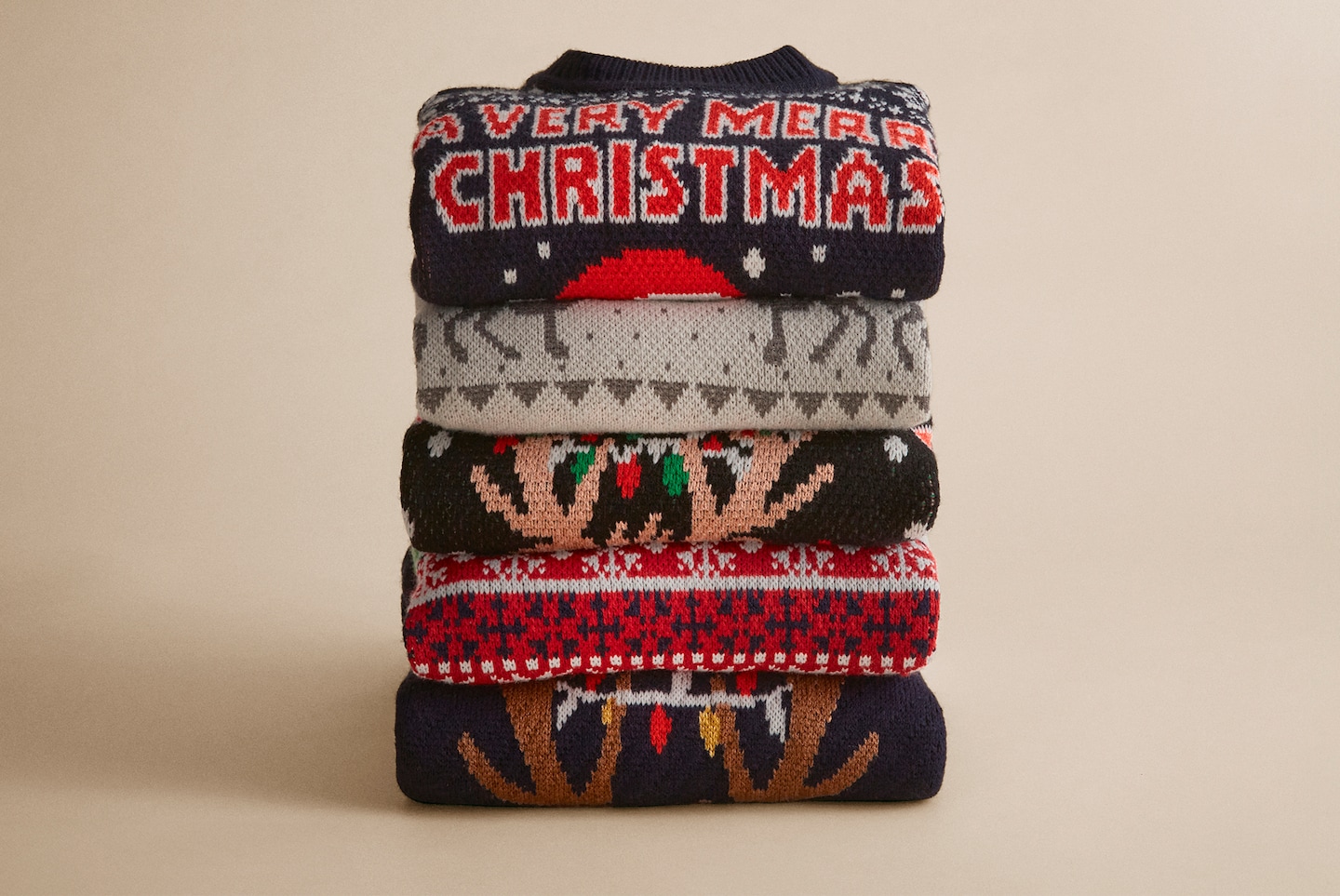 Folded Christmas Jumpers are pictured including Christmas Novelty Reinbeer Jumper