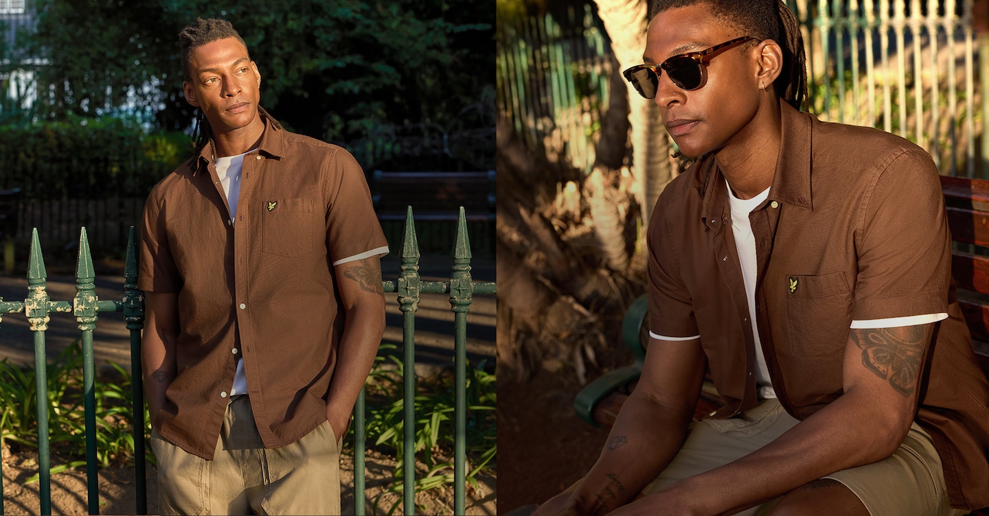 Model wears Lyle & Scott Short Sleeve Oxford Shirt - Walnut sat in a Summer park