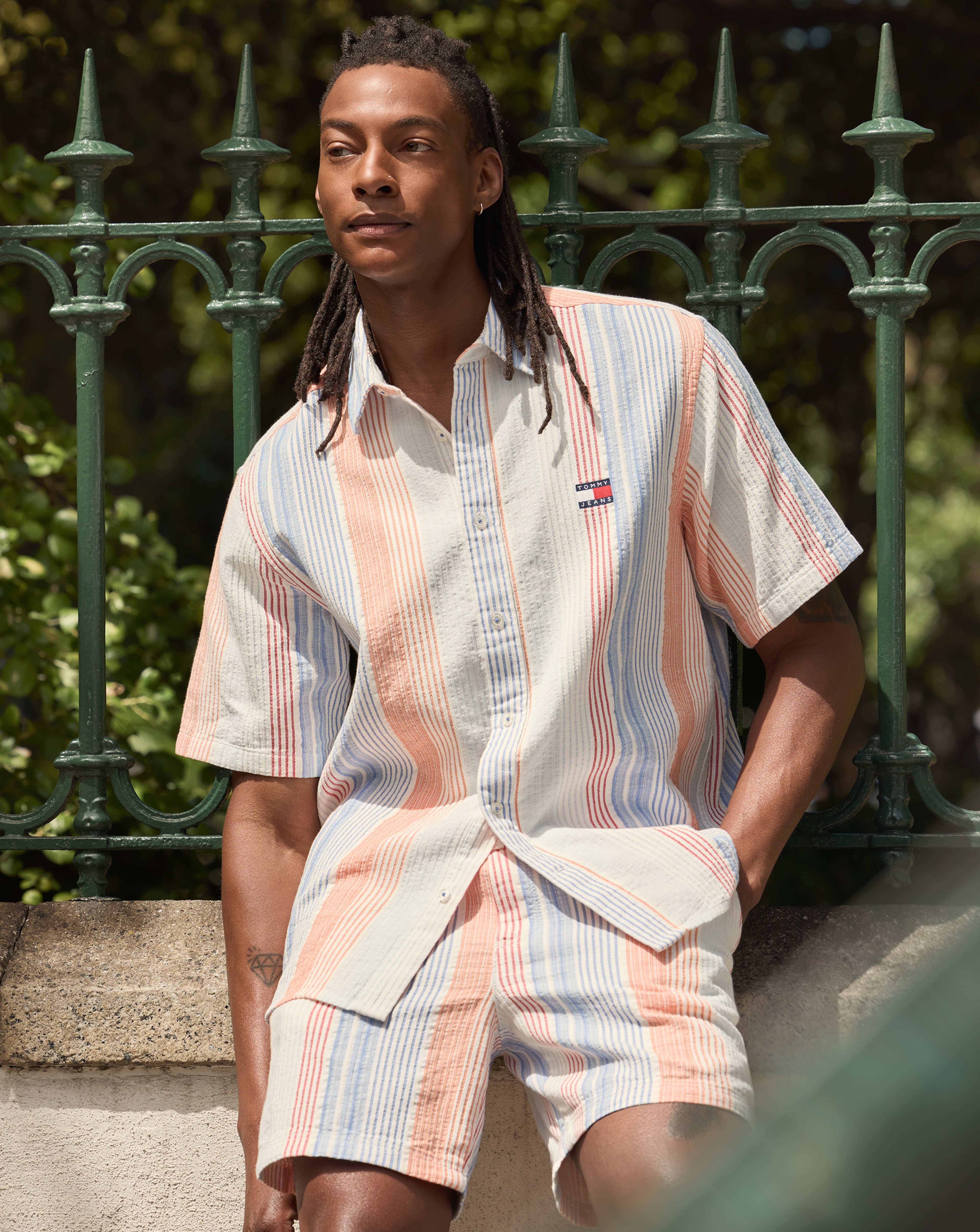 Model wears Tommy Jeans Short Sleeve Relax Stripe Short Sleeve Shirt - White and Shorts