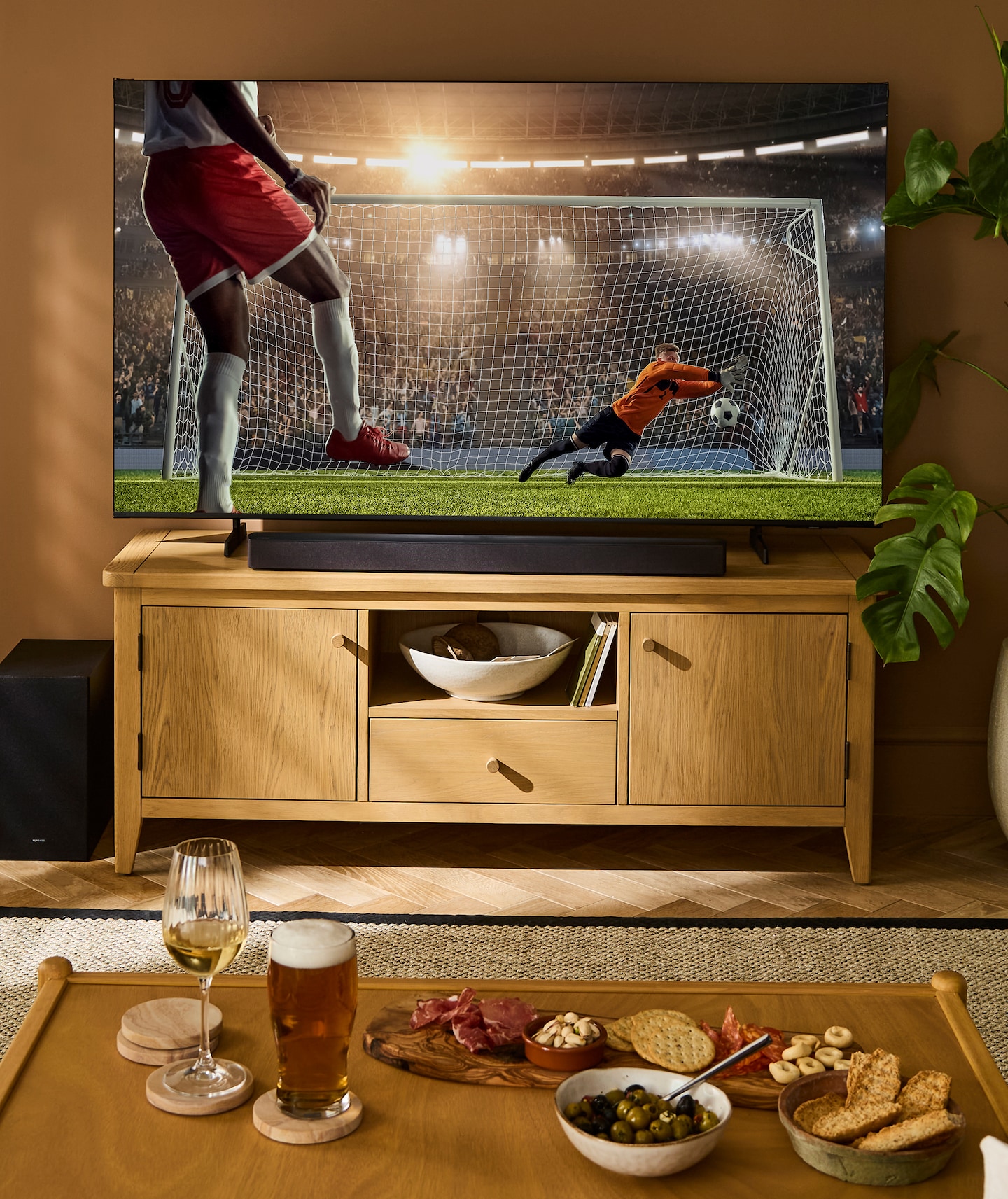 Pictured shows large TV screen in modern lounge watching a football match