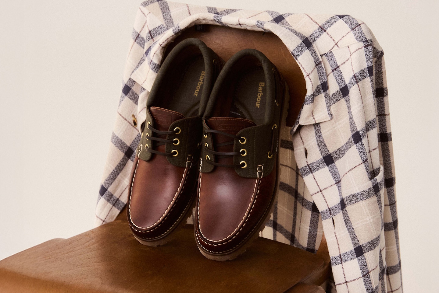 Barbour Rothley Boat Shoe - Dark Brown are pictured on chair withBarbour Vennel Textured Tartan Overshirt - Tartan