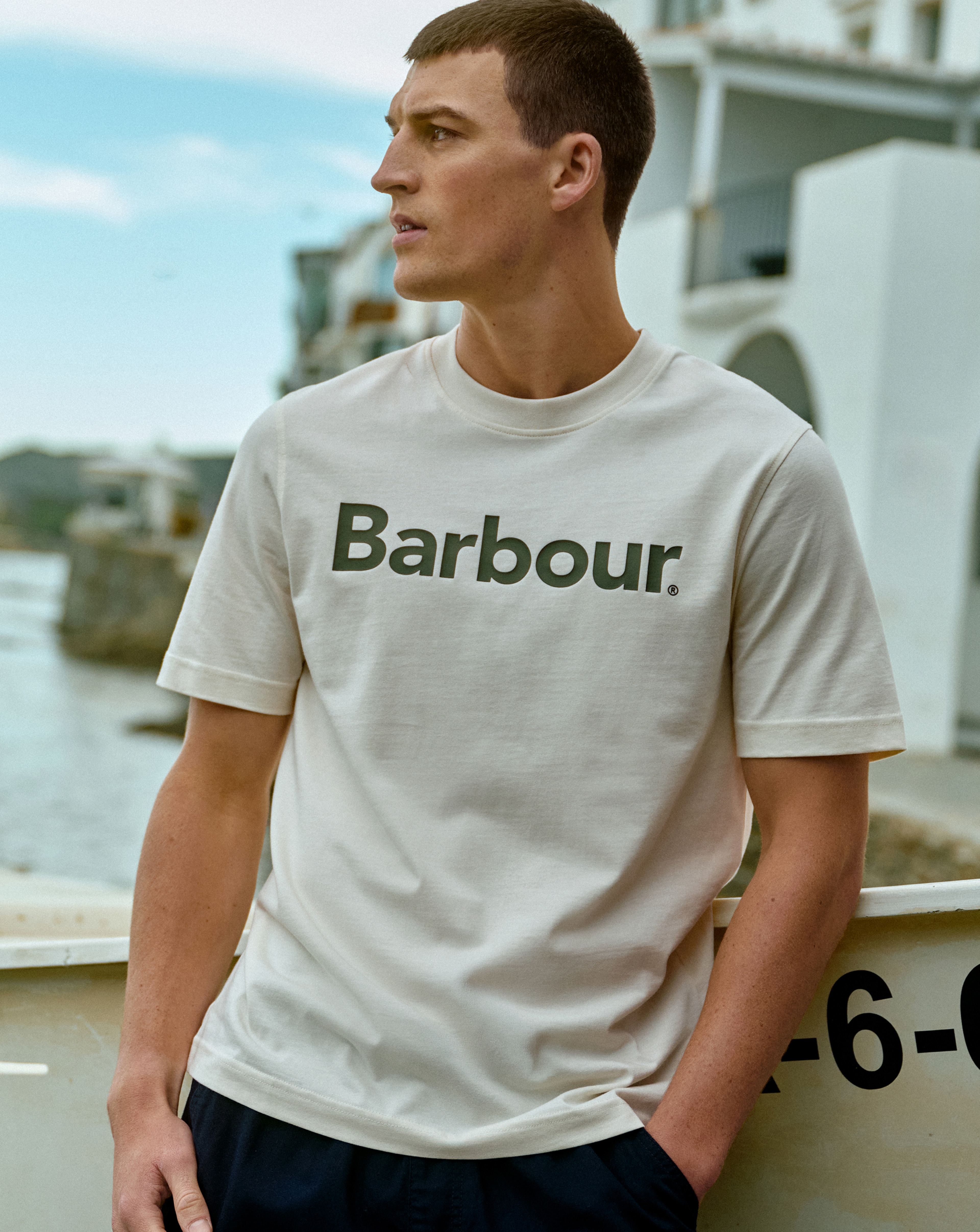Model is wearing a white Barbour short sleeve logo relaxed t-shirt.