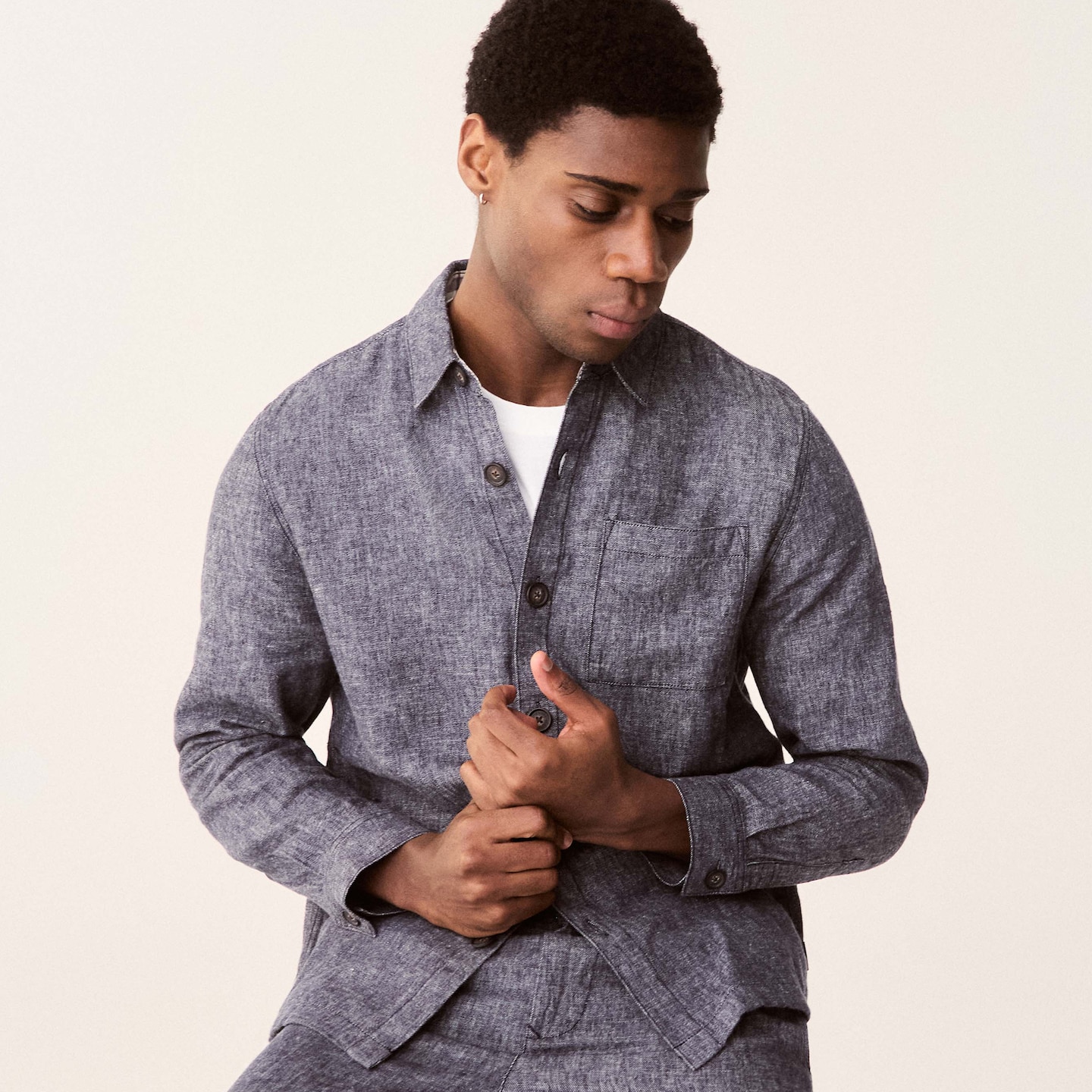 Model is wearing a navy Barbour Stillwater linen blend overshirt with a white t-shirt underneath.