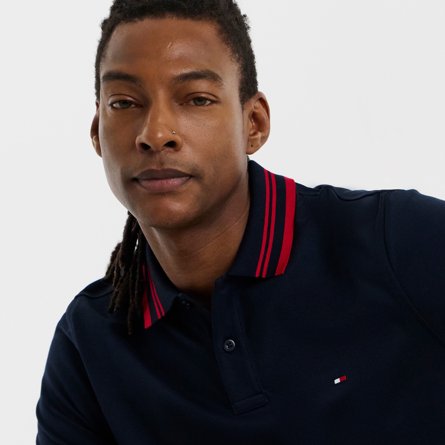 Am model is wearing a navy Tommy Hilfiger Mercerised Jacquard polo.