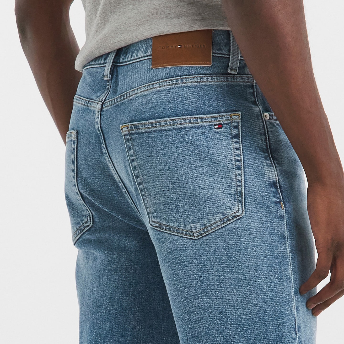 Model is wearing a blue Tommy Hilfiger Madison regular straight jeans.