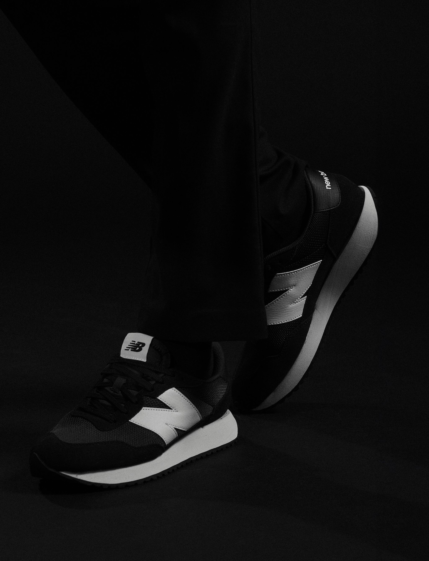 Model wears black and white New Balance trainers