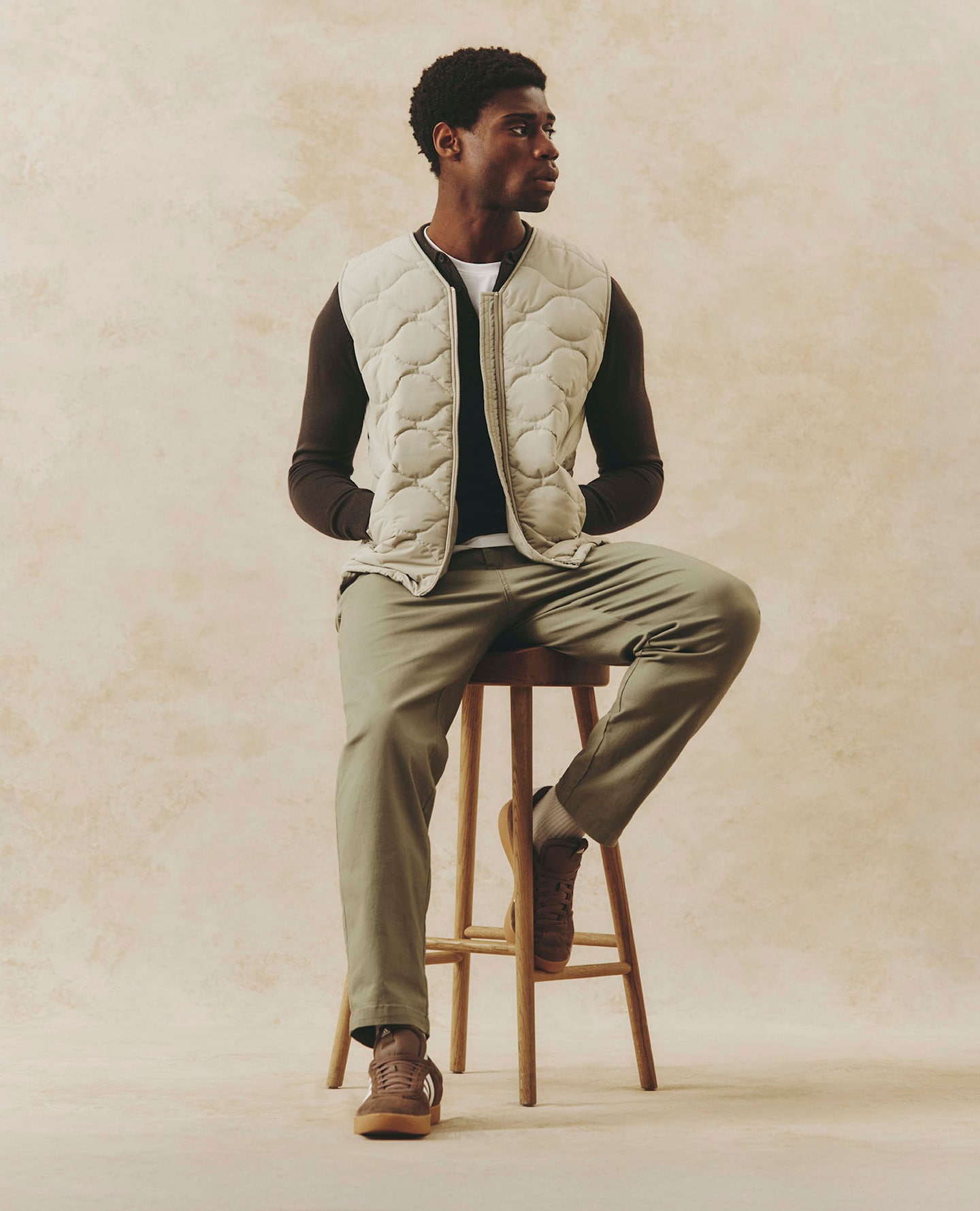 Model wears Onion Quilt Zip Through Gilet in Taupe with Khaki Cotton Stretch Cargo Trouser