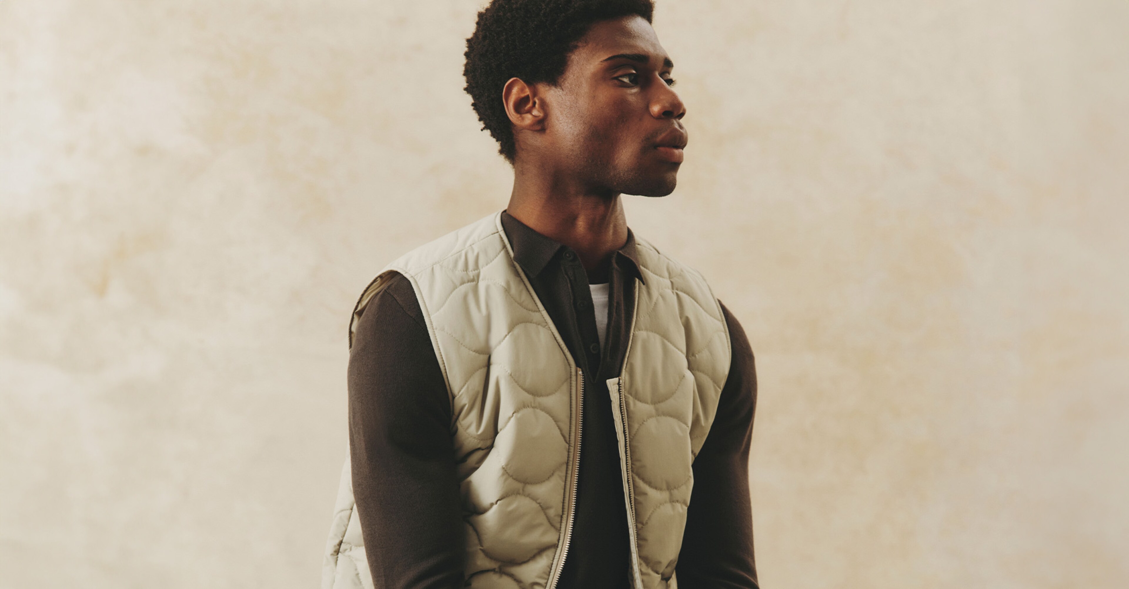 Model wearing brown long sleeved t-shirt and a quilted vest