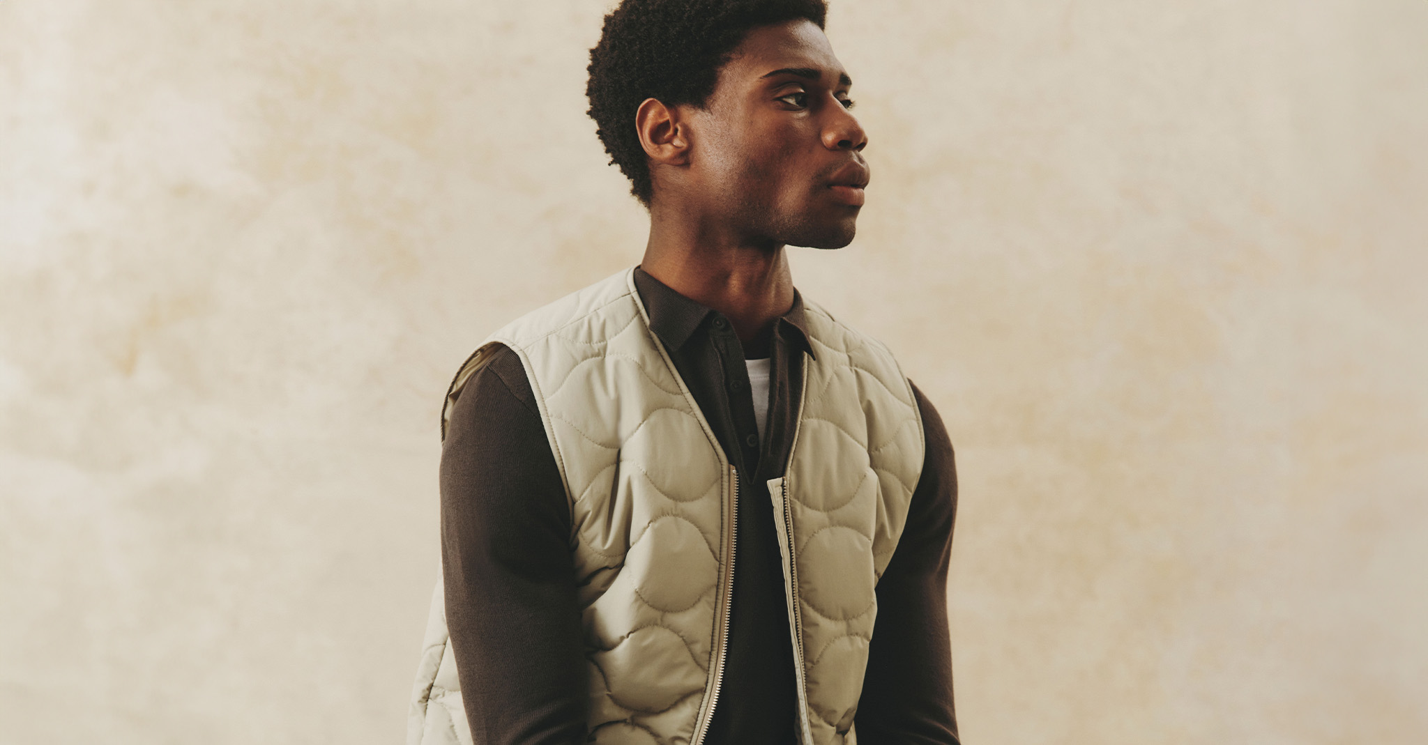 Model wearing brown long sleeved t-shirt and a quilted vest