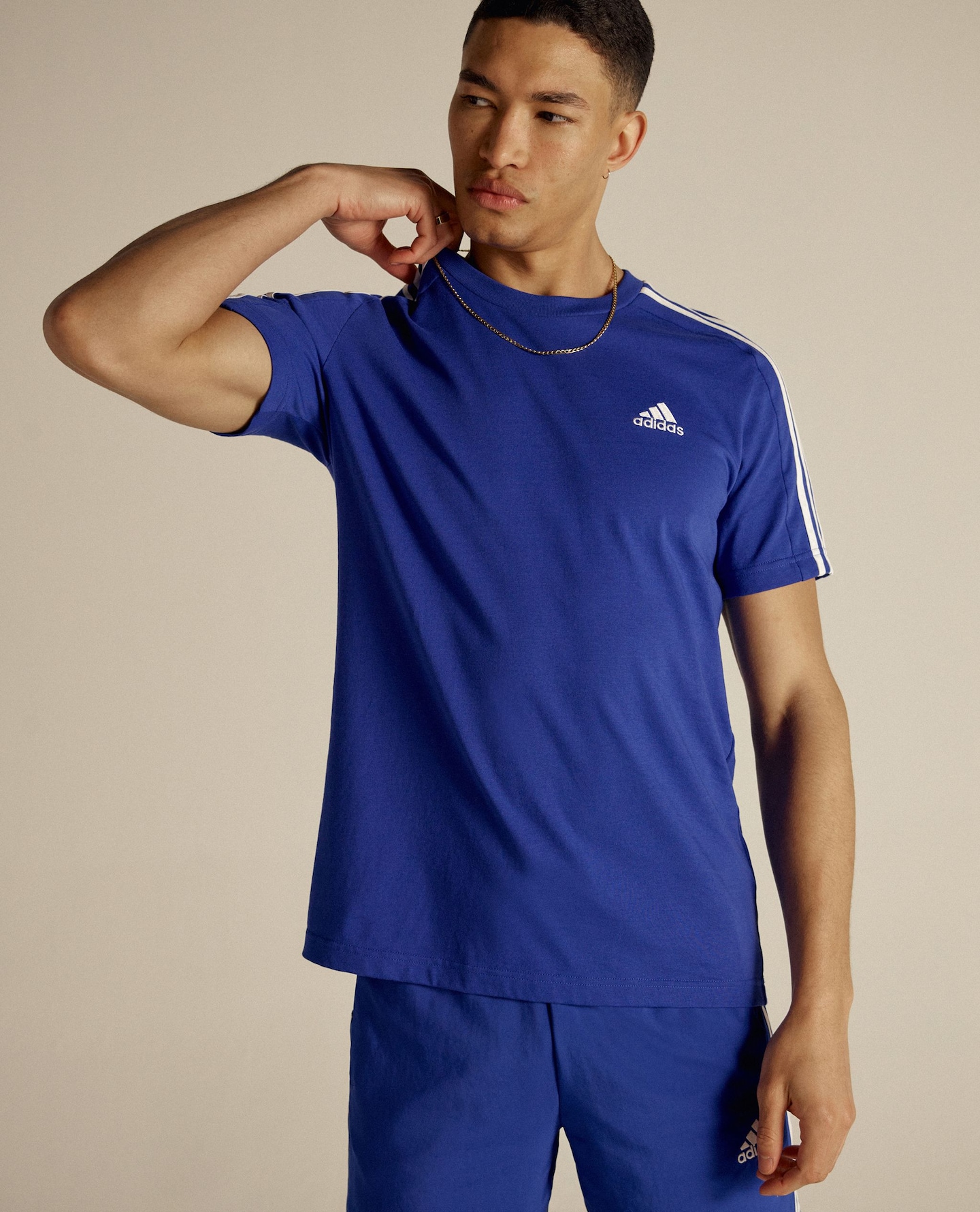 Model wears blue adidas sports top and blue adidas shorts