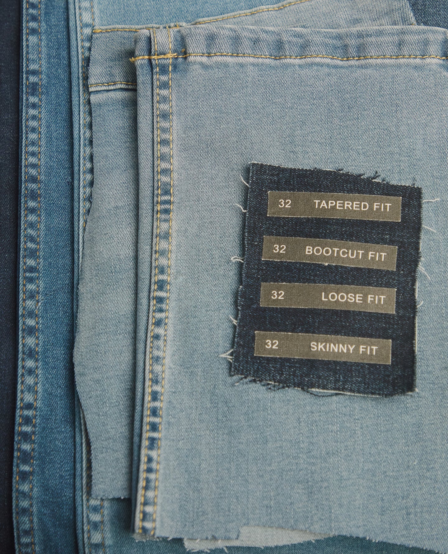 Denim material with labels laid over the top. The label's read "Tapered fit", "Bootcut fit", "Loose fit" and "Skinny fit"