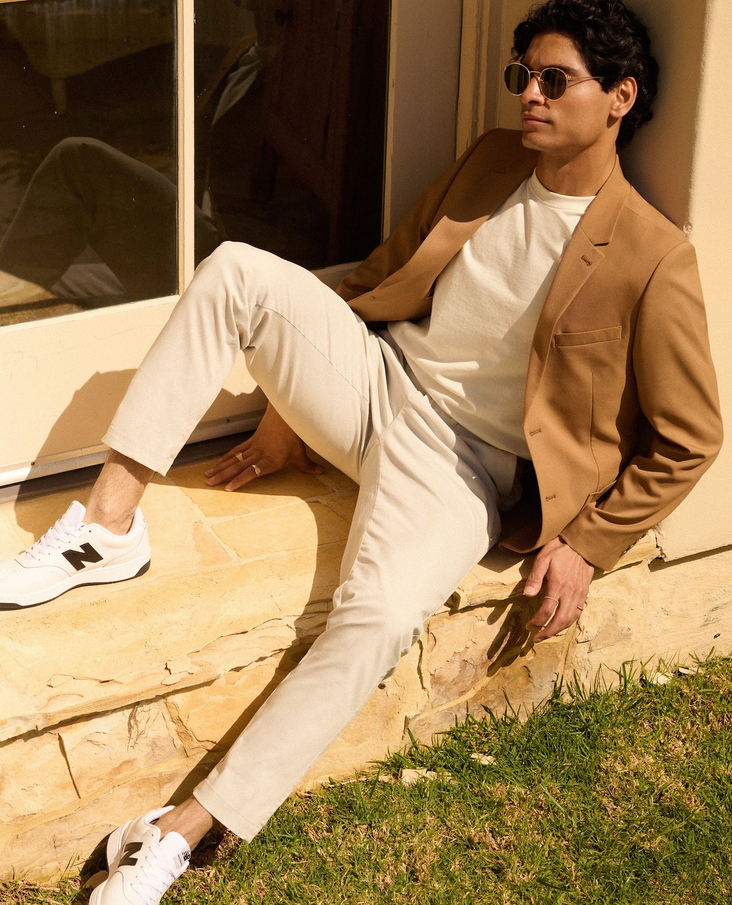 Guy sat on a step wearing chinos and a light jacket