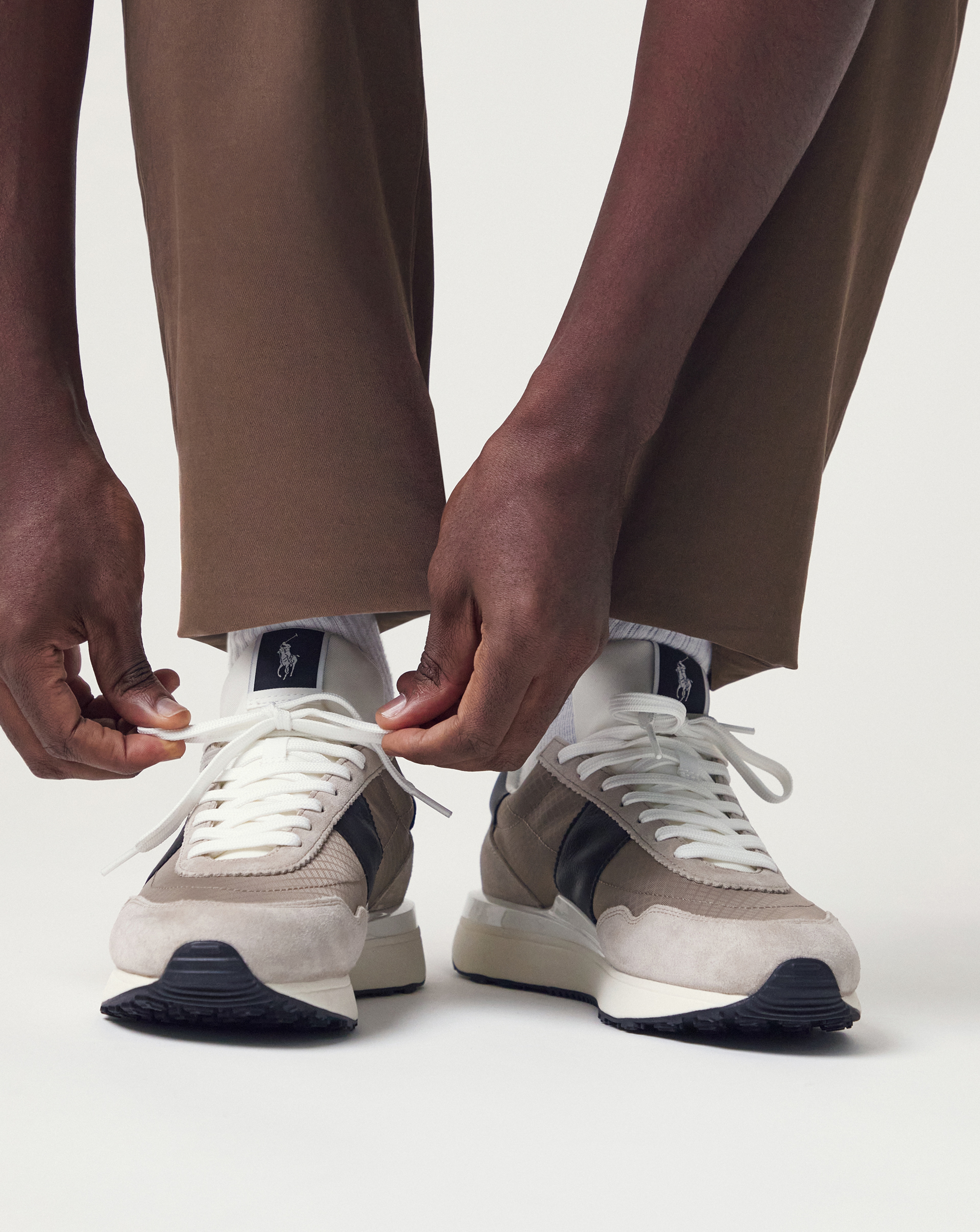 Model wears Polo Ralph Lauren Train 89 Trainers - Beige