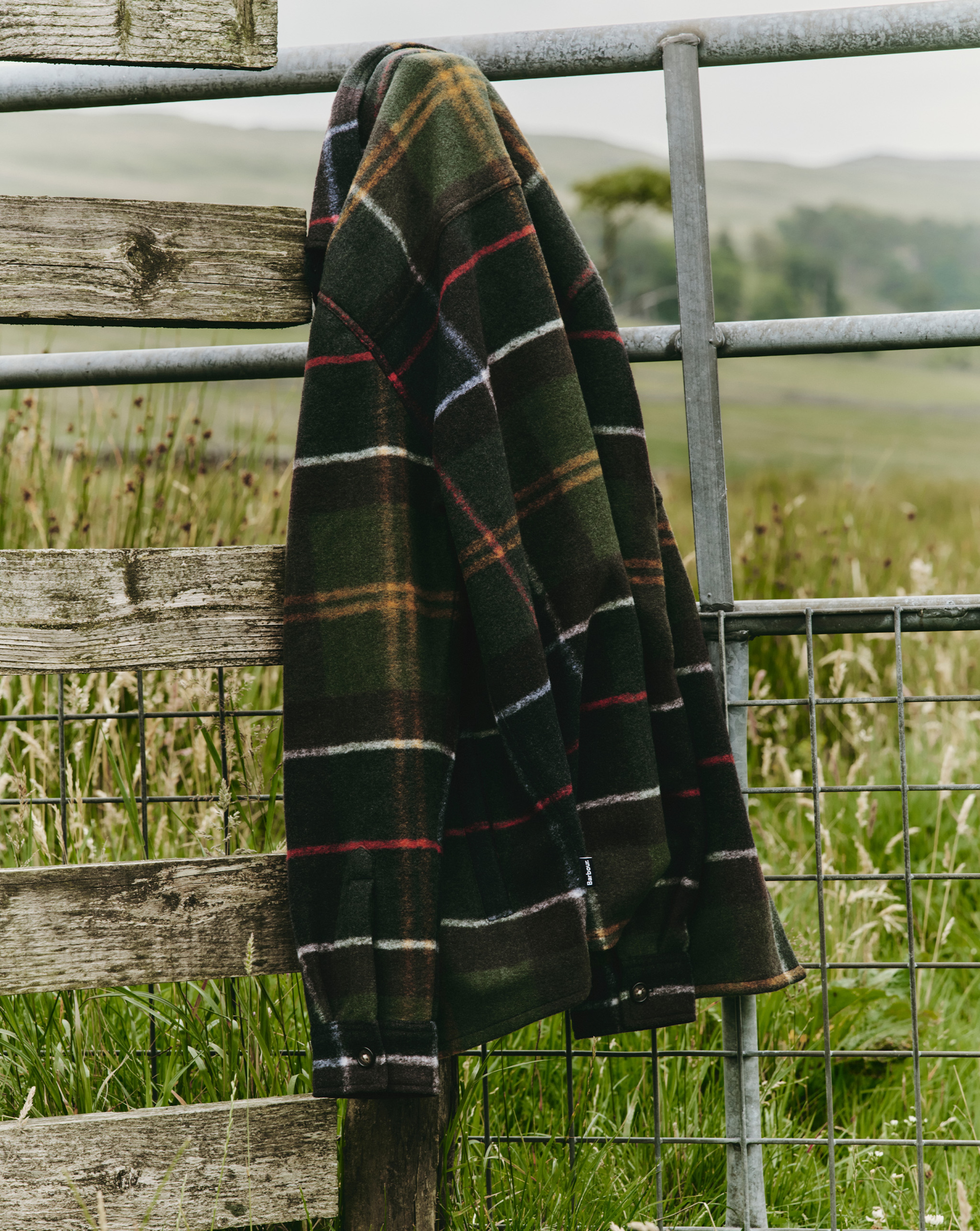 Barbour chequered shirt hanging from a fence