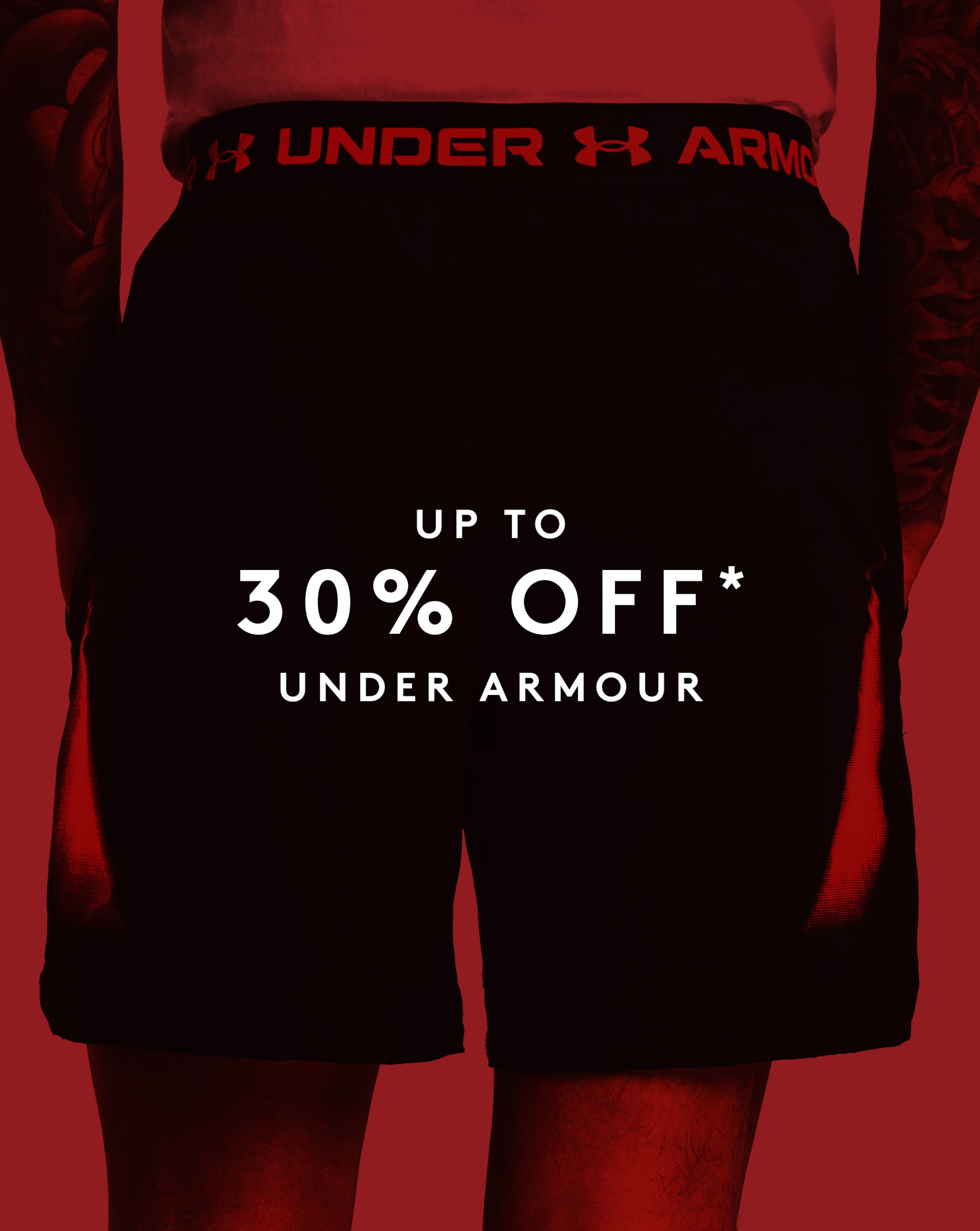 Model wearing Under Armour shorts with a red sale overlay. Up to 30% off Under Armour