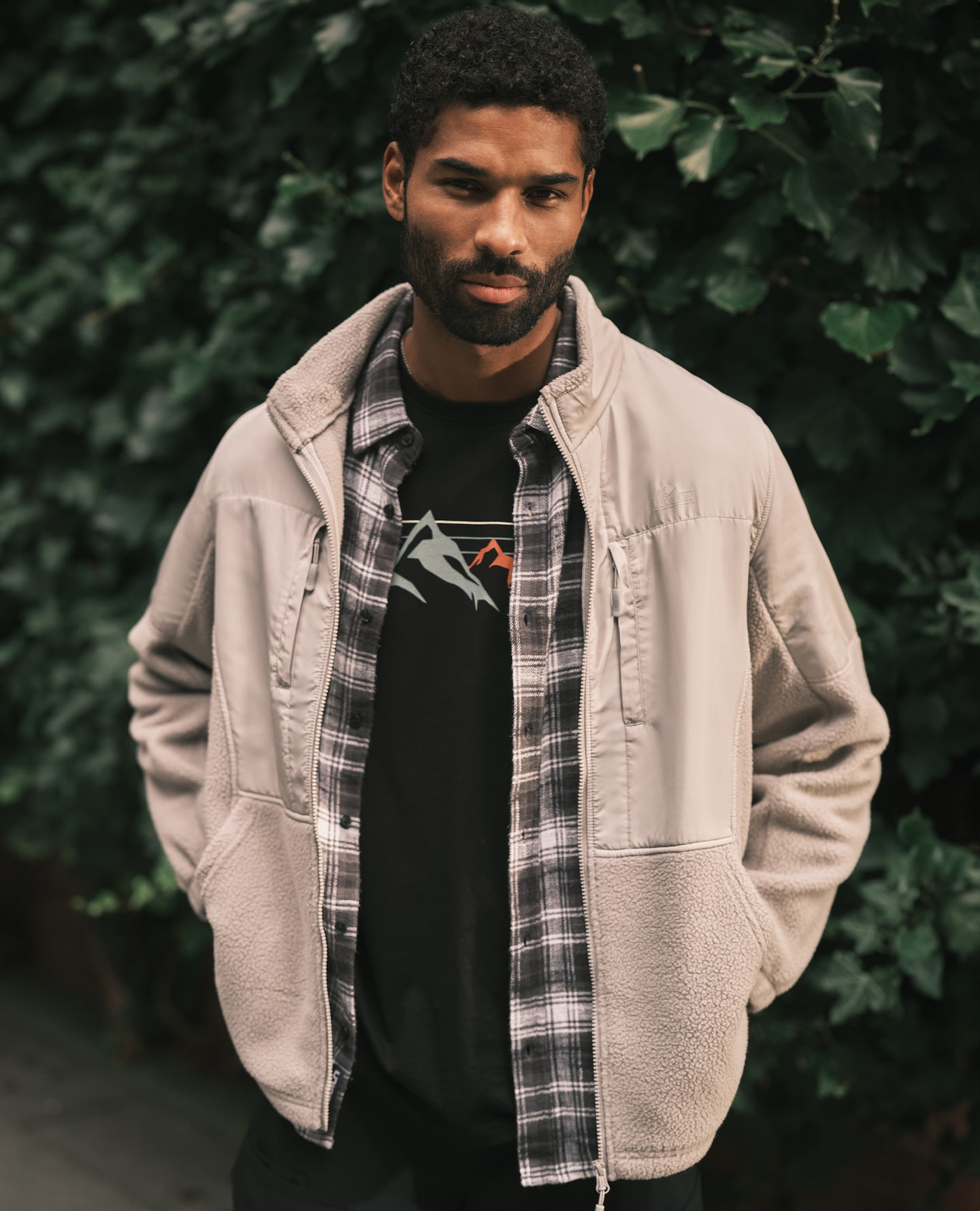 Model wearing layers and a cream jacket