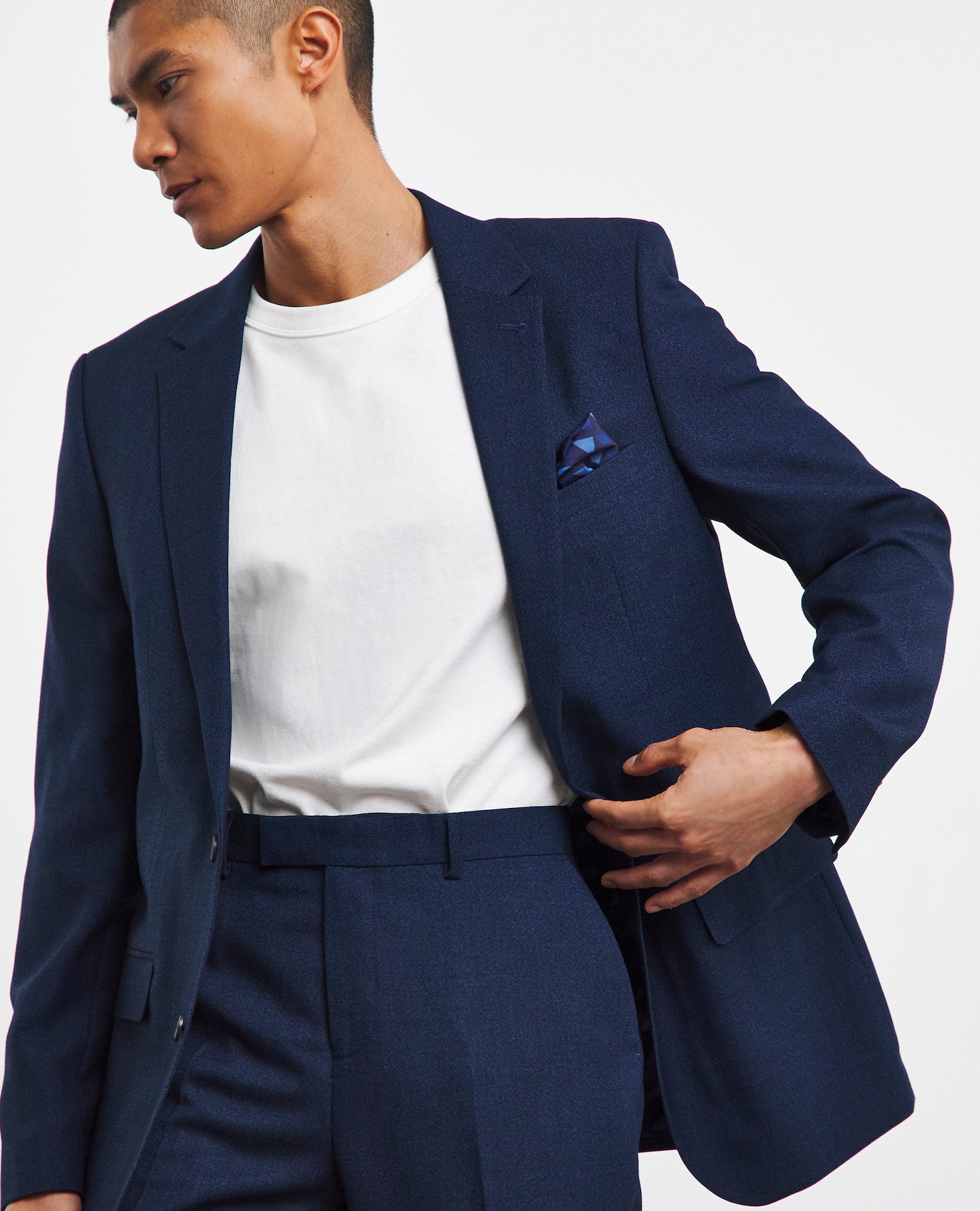 Model wearing navy blue two piece suit with white t-shirt