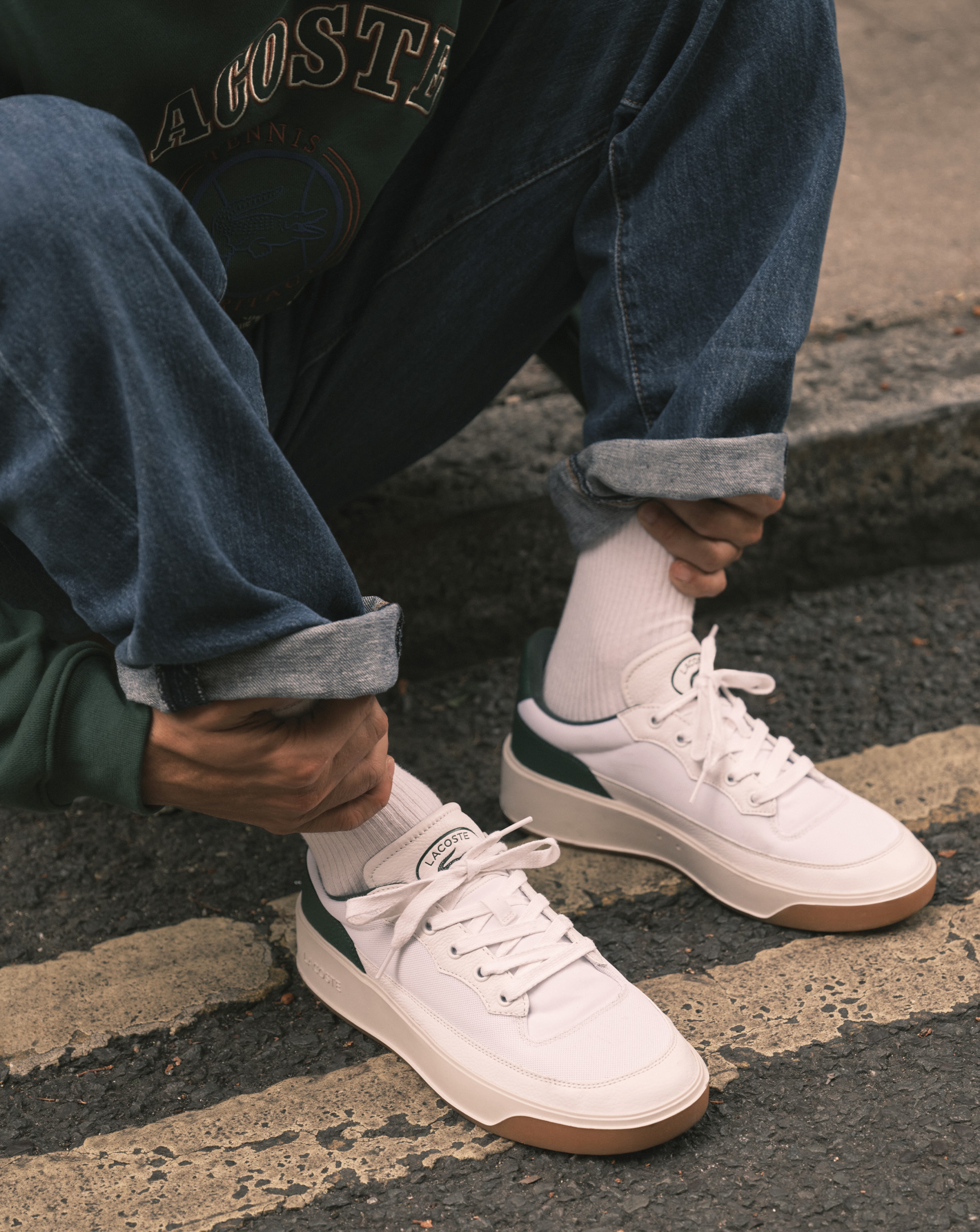 Model wearing white Lacoste trainers