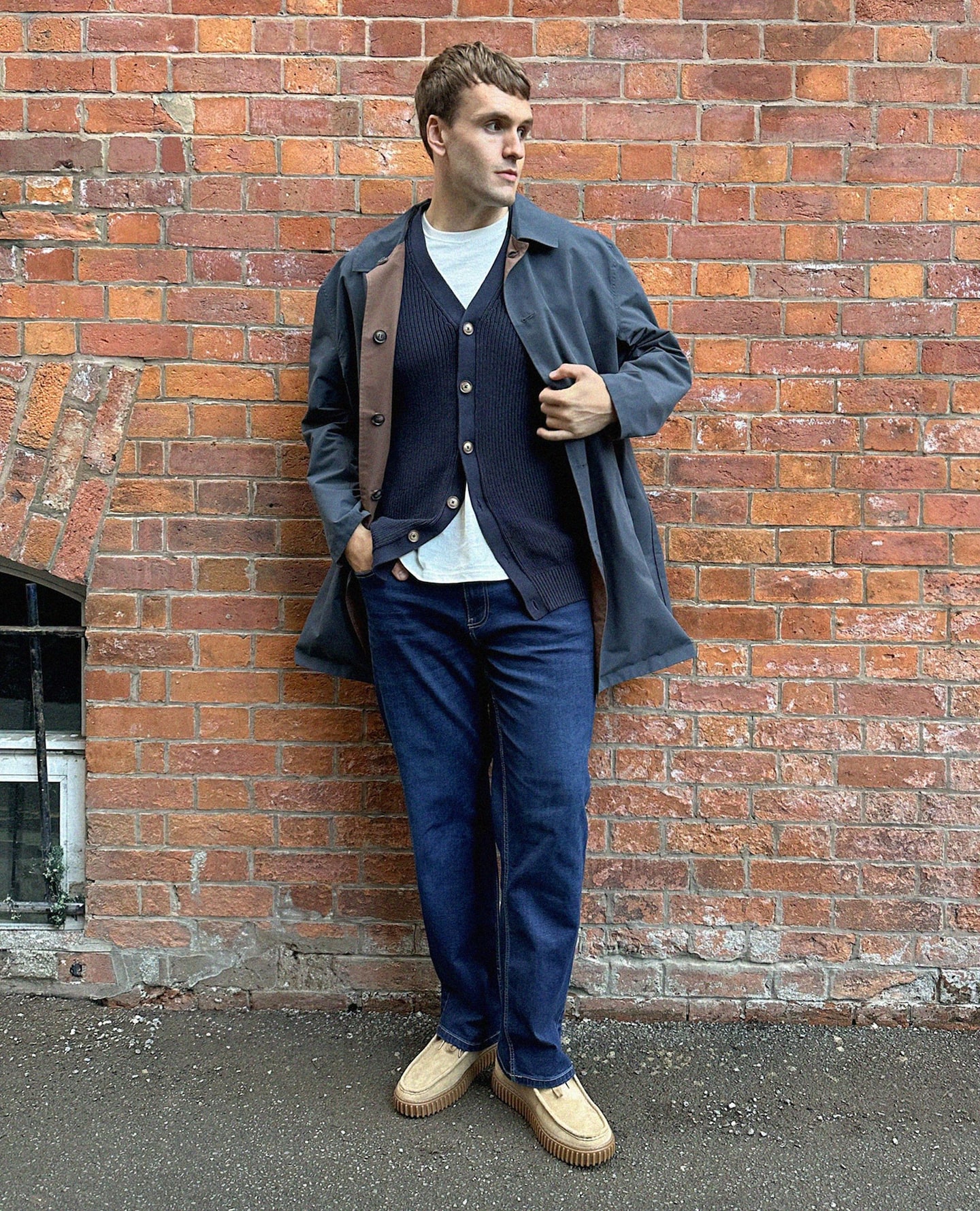 A man stood wearing a navy overcoat