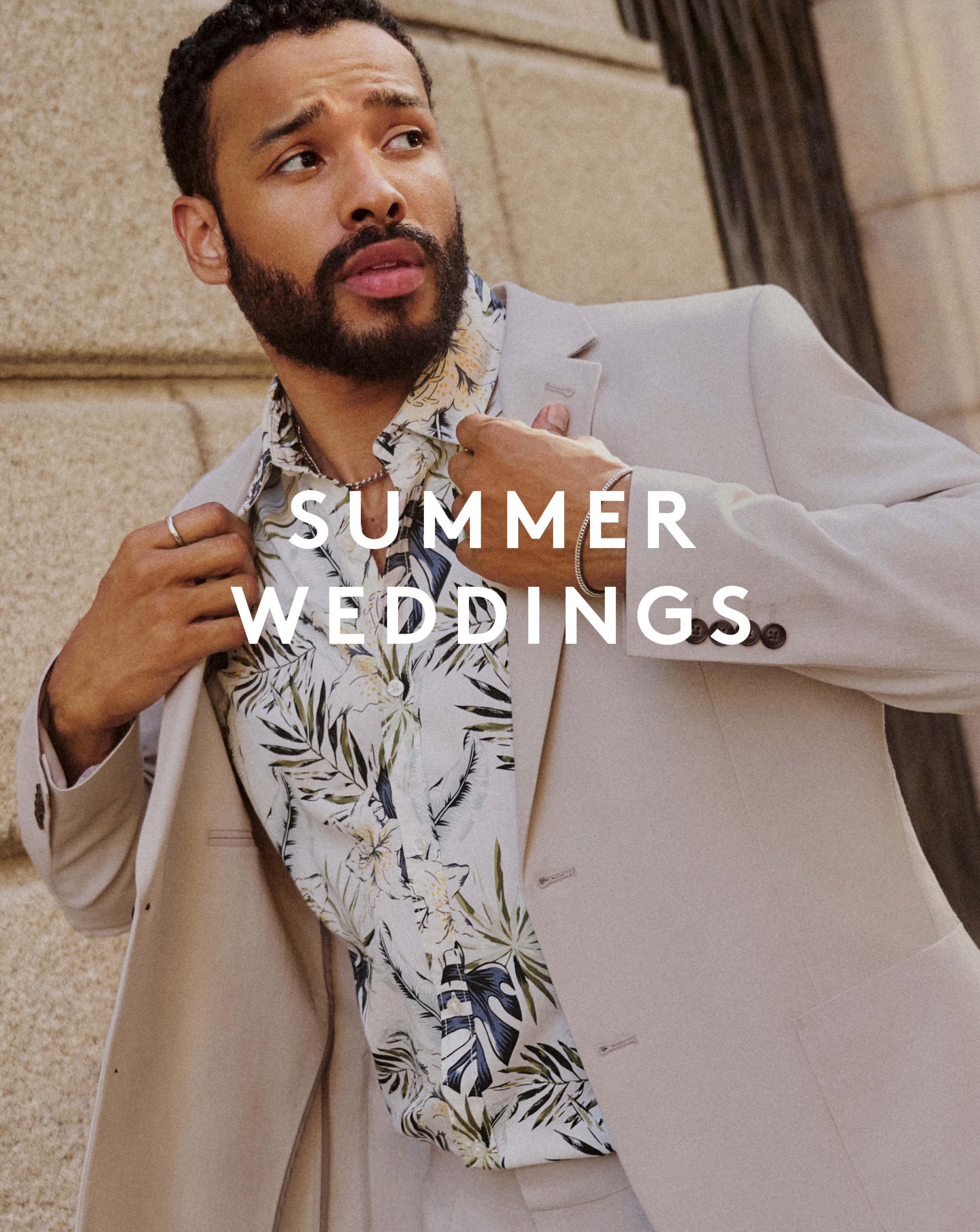 Model wearing beige blazer with a white patterned shirt underneath