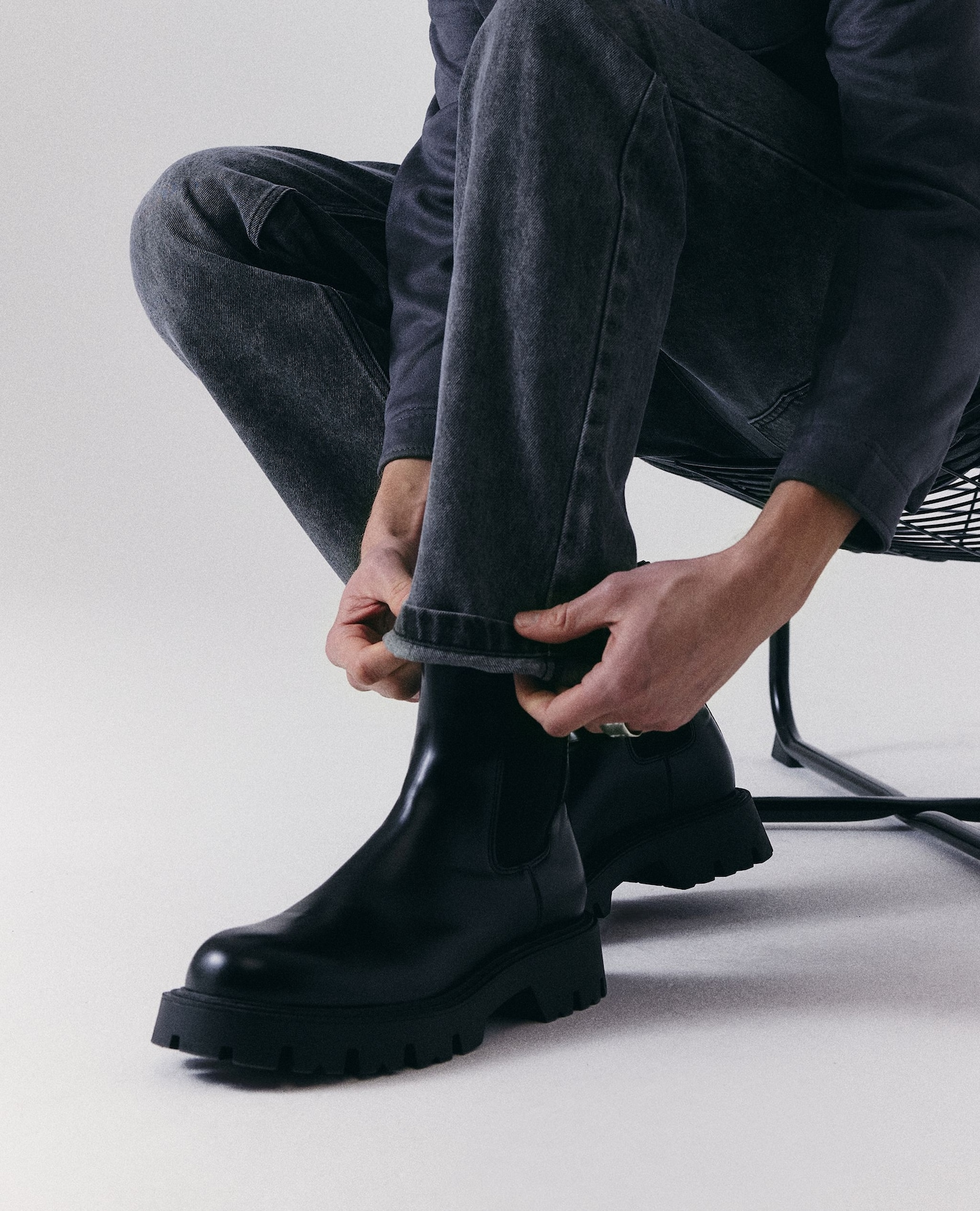 Model sat wears black boots