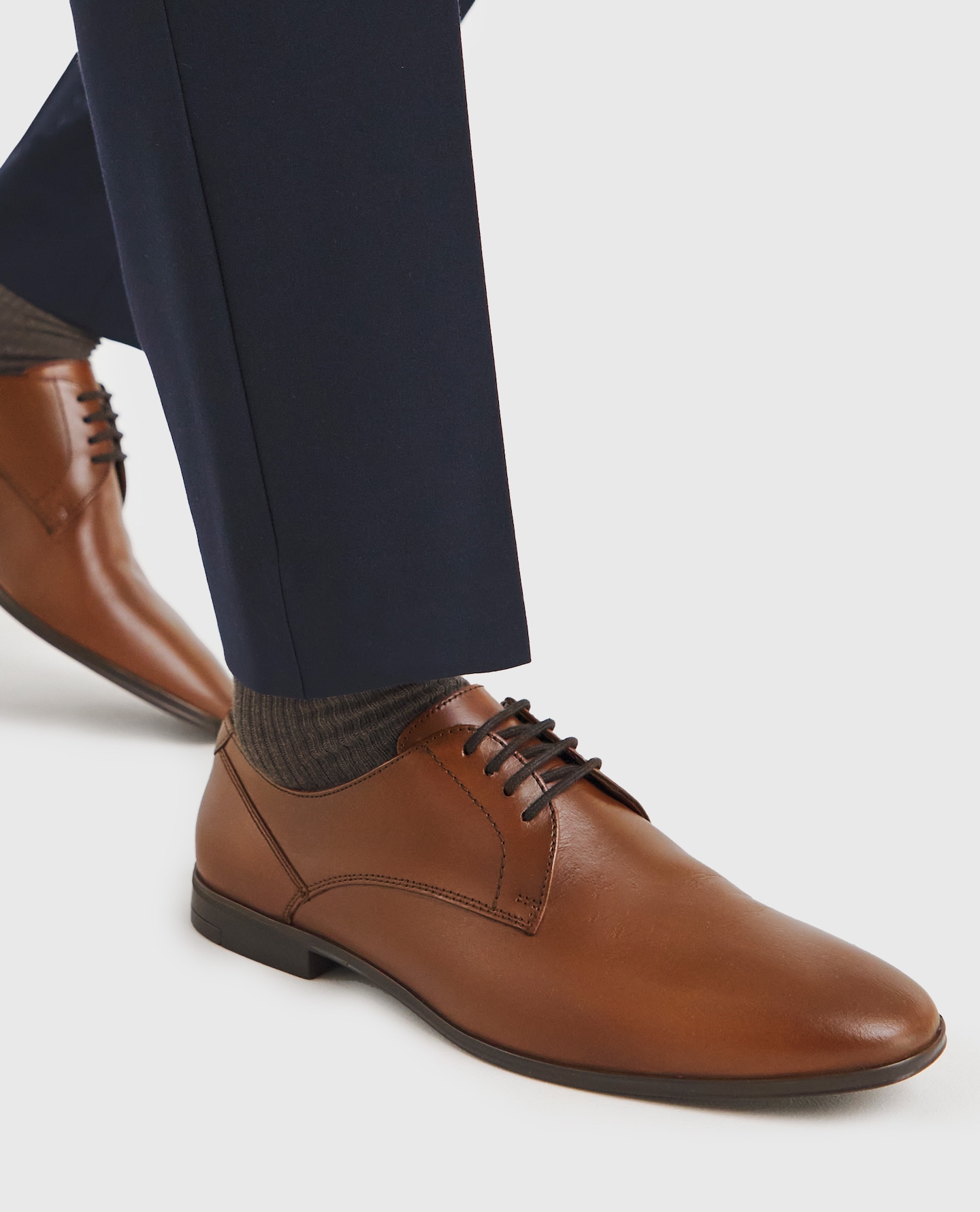 Model wearing a brown pair of loafers