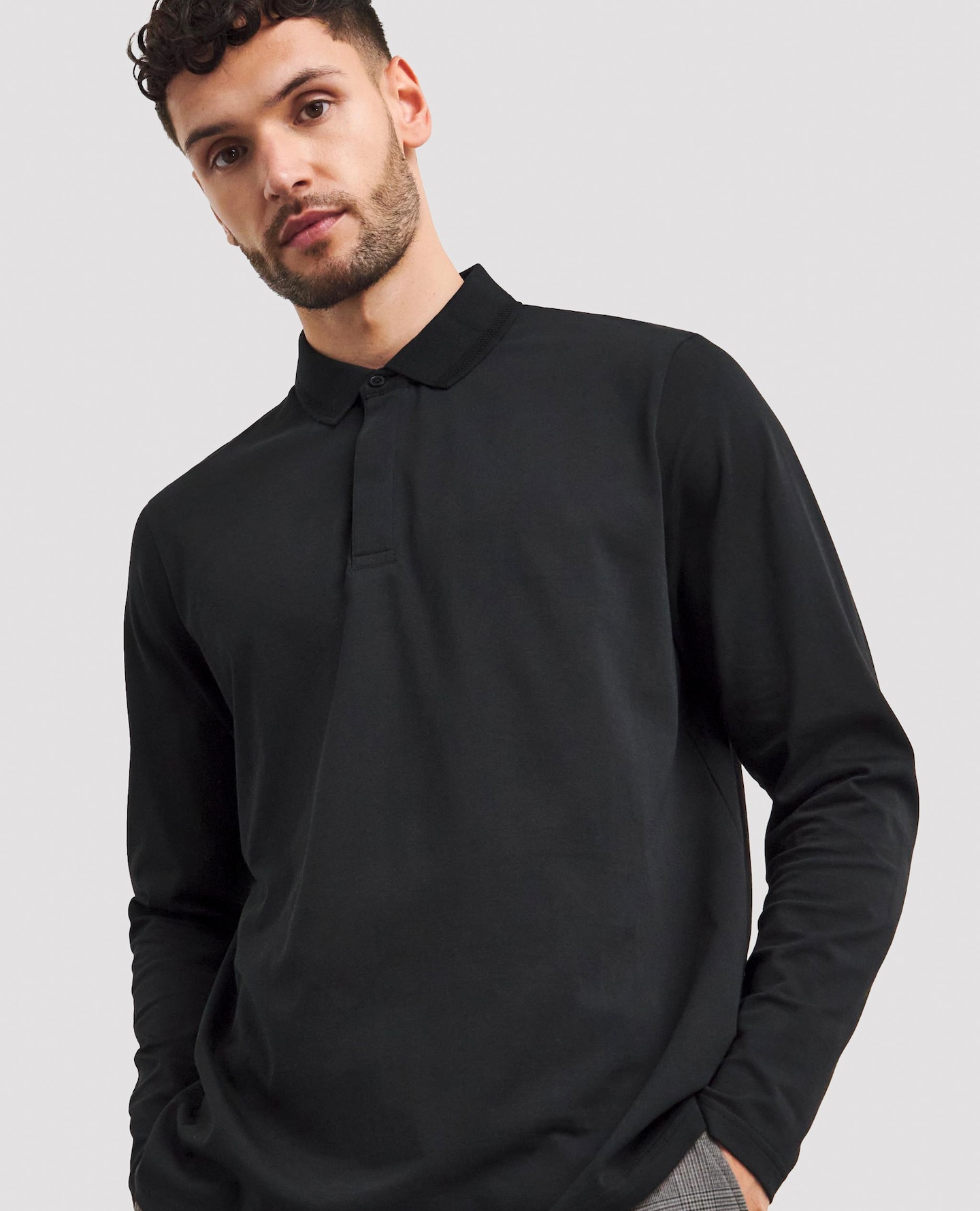Model wears plain black polo shirt