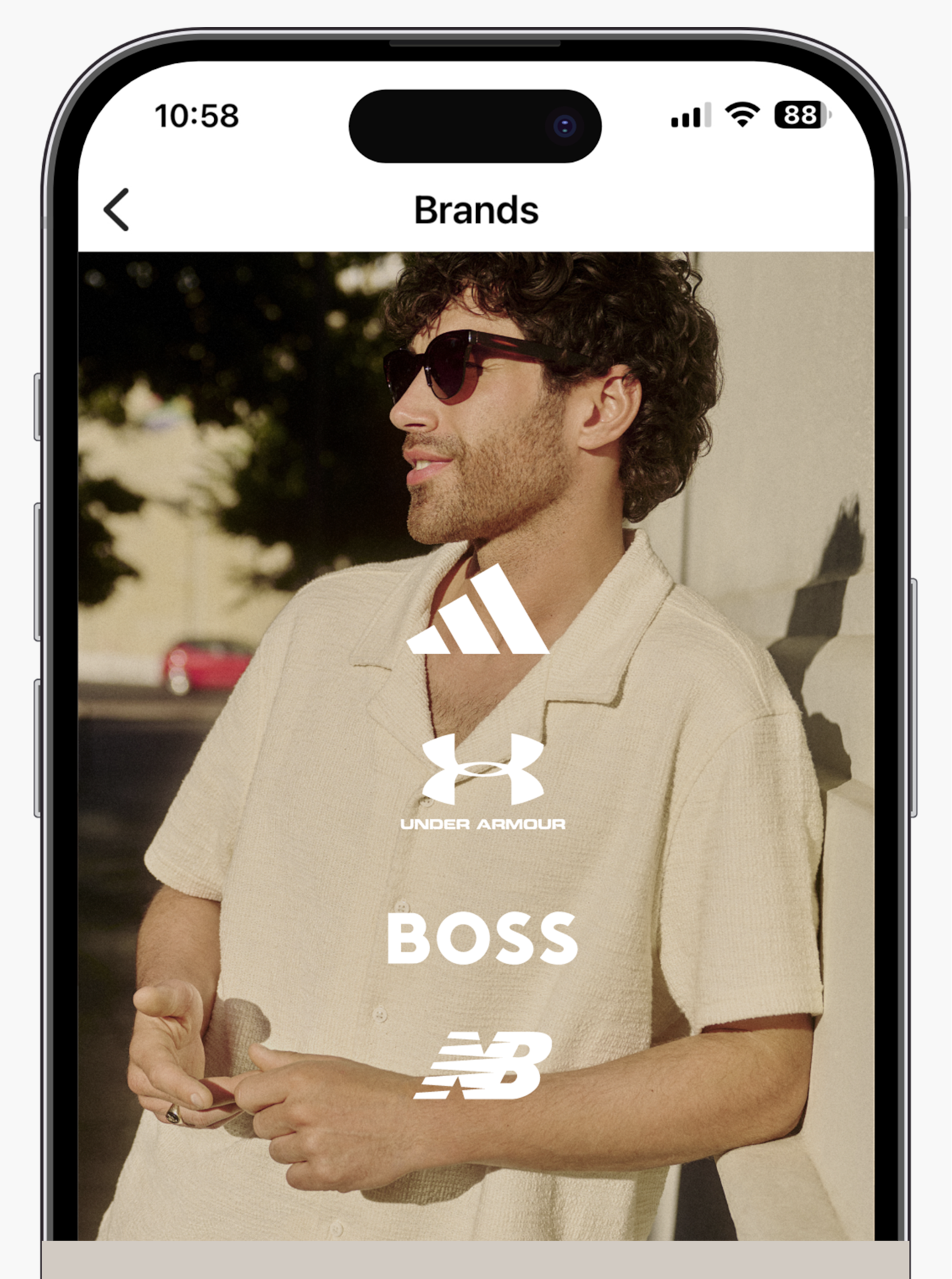 Model wears cream summer shirts with brands, adidas, Under Armour, BOSS and New Balance displayed