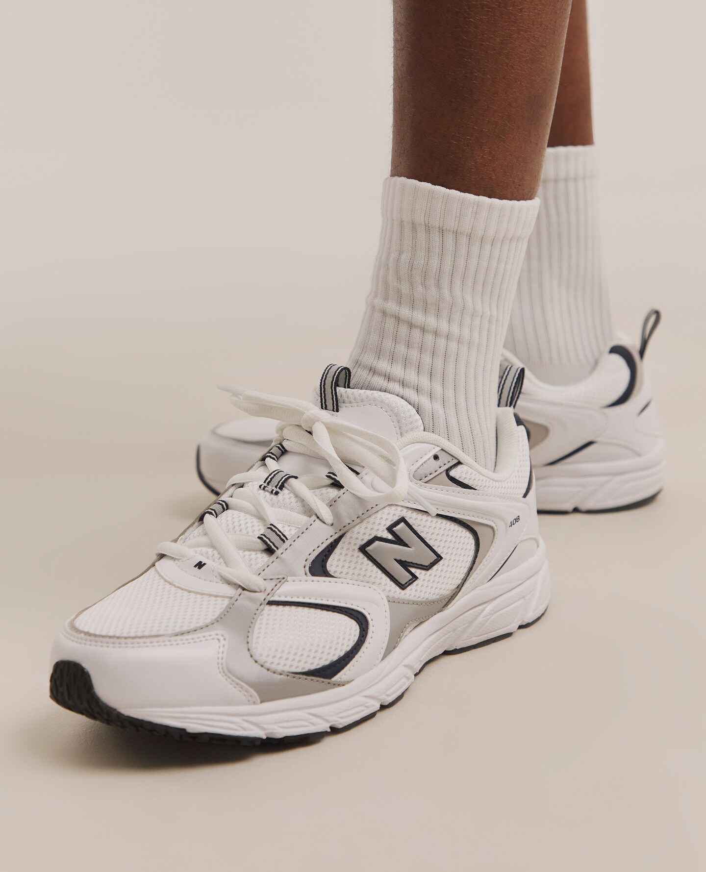 Model wearing white New Balance trainers