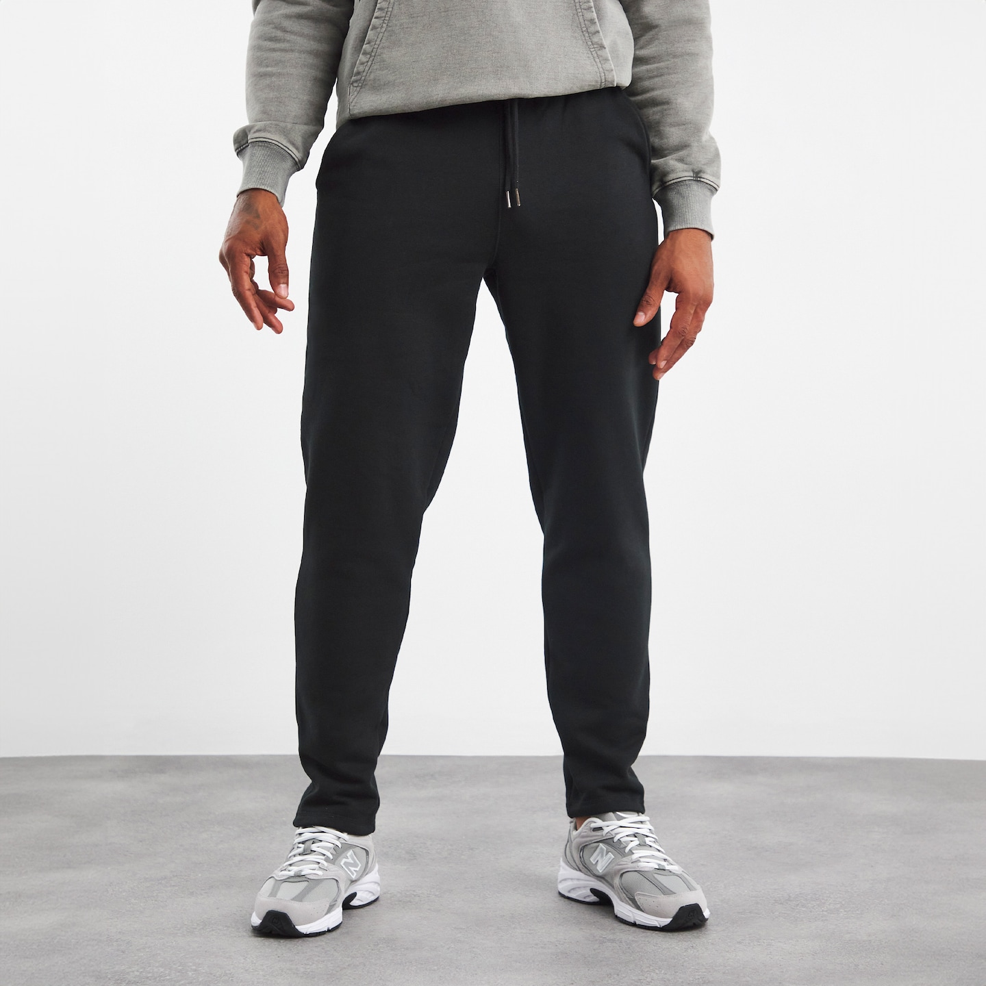 Model wearing black tracksuit bottoms