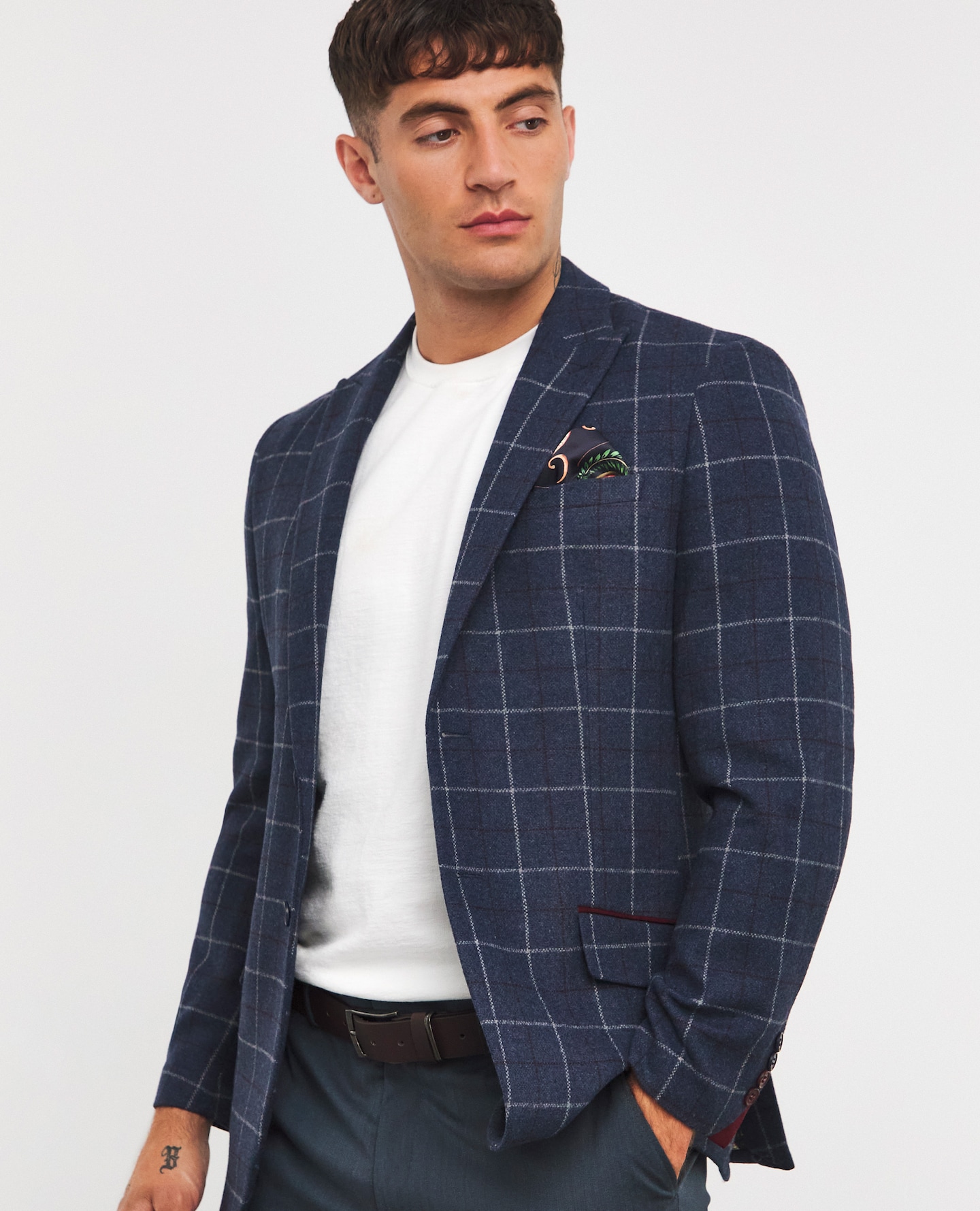Model wearing check, navy blue blazer with white t-shirt