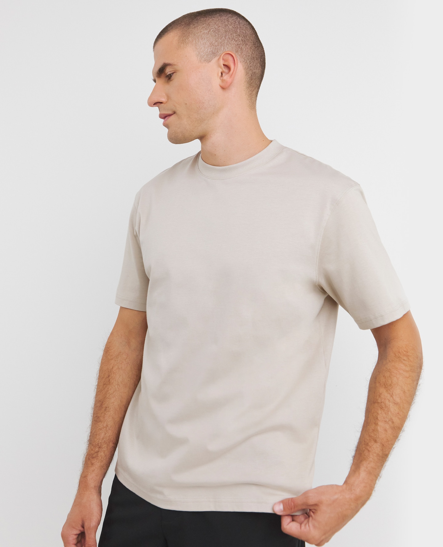 Moddel wearing a regular length beige t-shirt