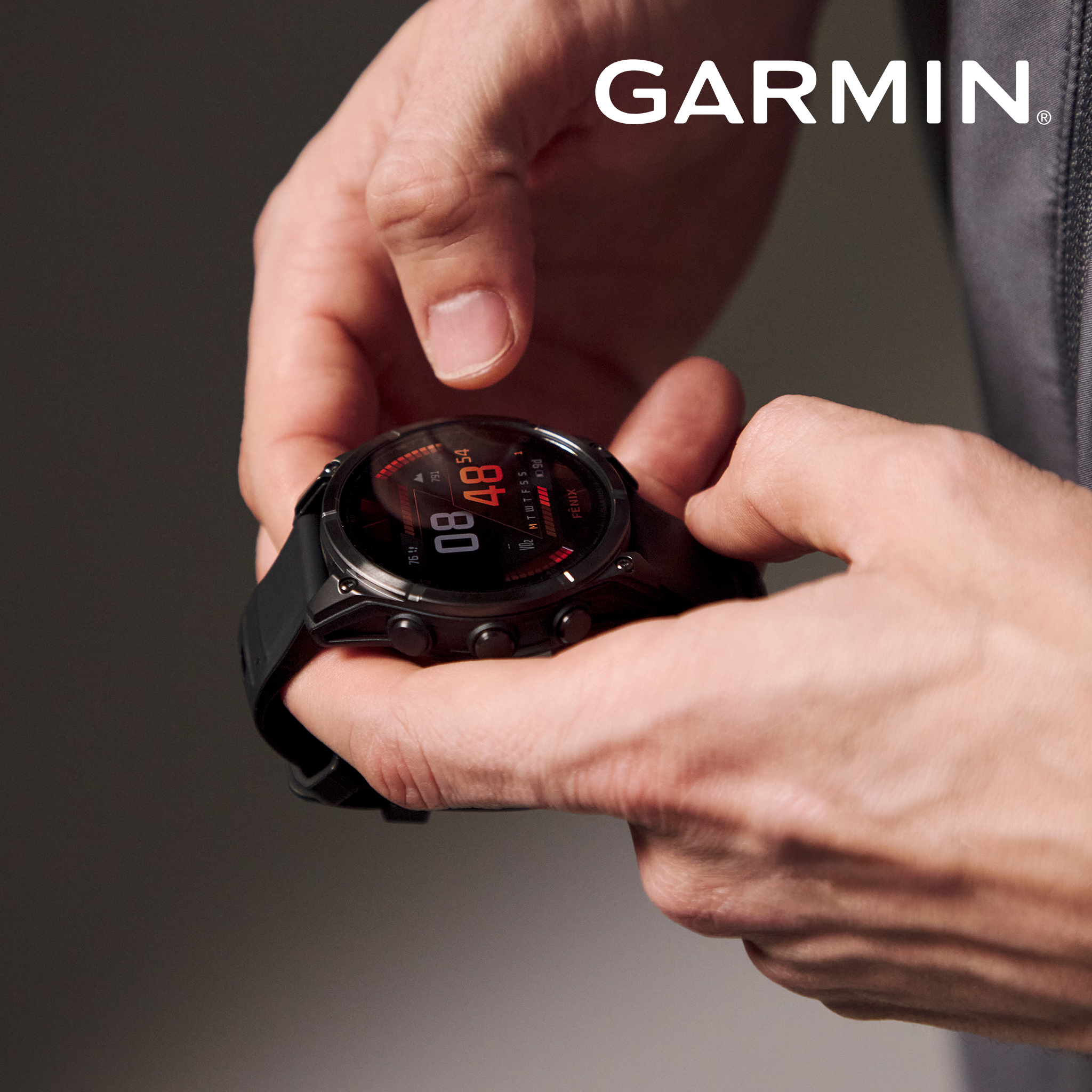 Model is holding Garmin Fenix 8 AMOLED 47mm Smart Watch - Slate Grey/Black