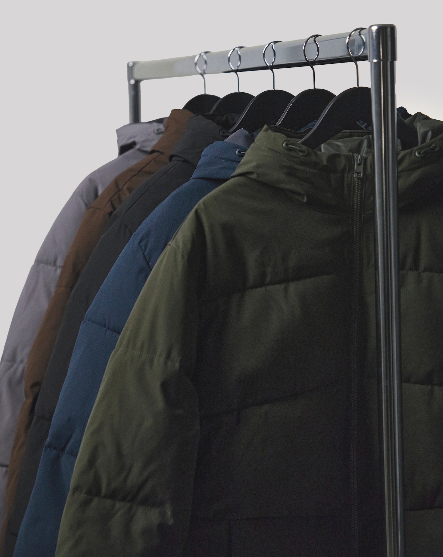 Jack & Jones Global Puffer Coat in Green, Navy, Black, Brown & grey are pictured on a rail