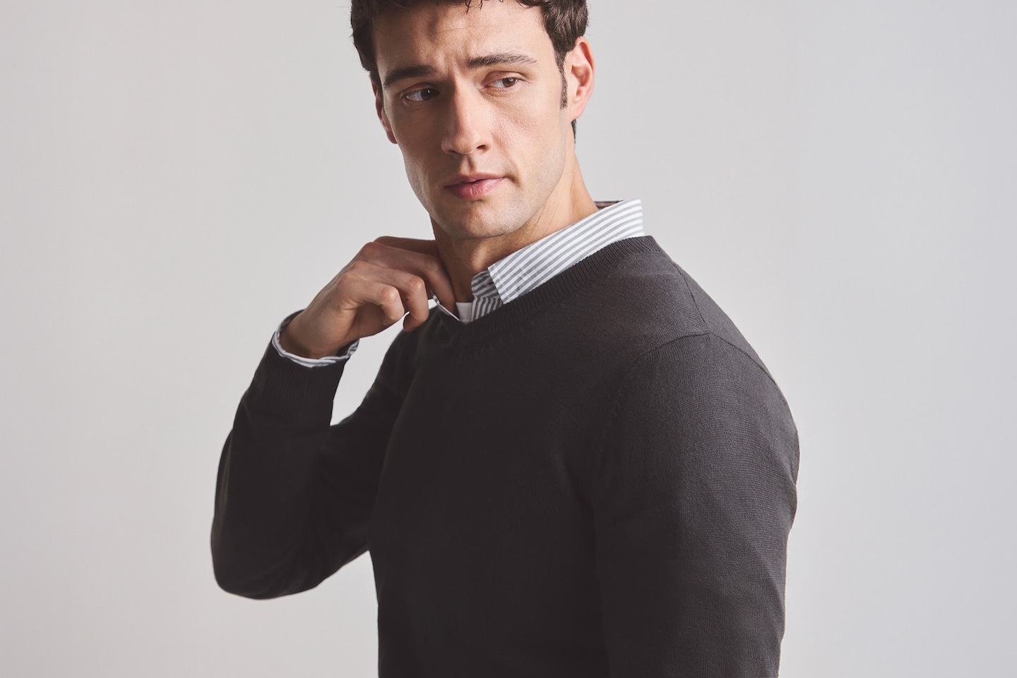 Model wears Value Knitted V Neck Jumper Long with Blue pin striped shirt