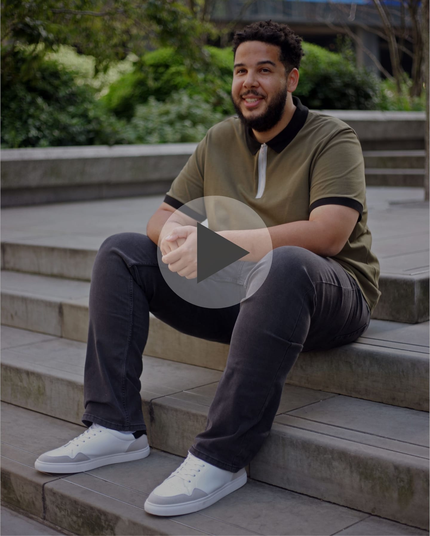 A video still of a man sat on steps