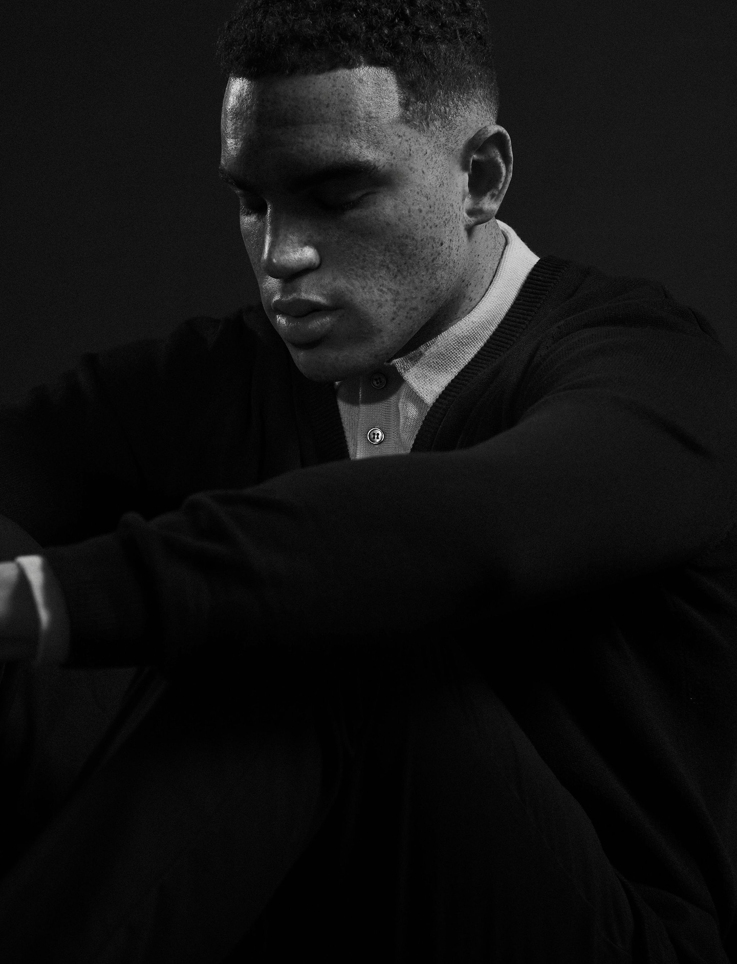 Model sat wearing white shirt and jumper