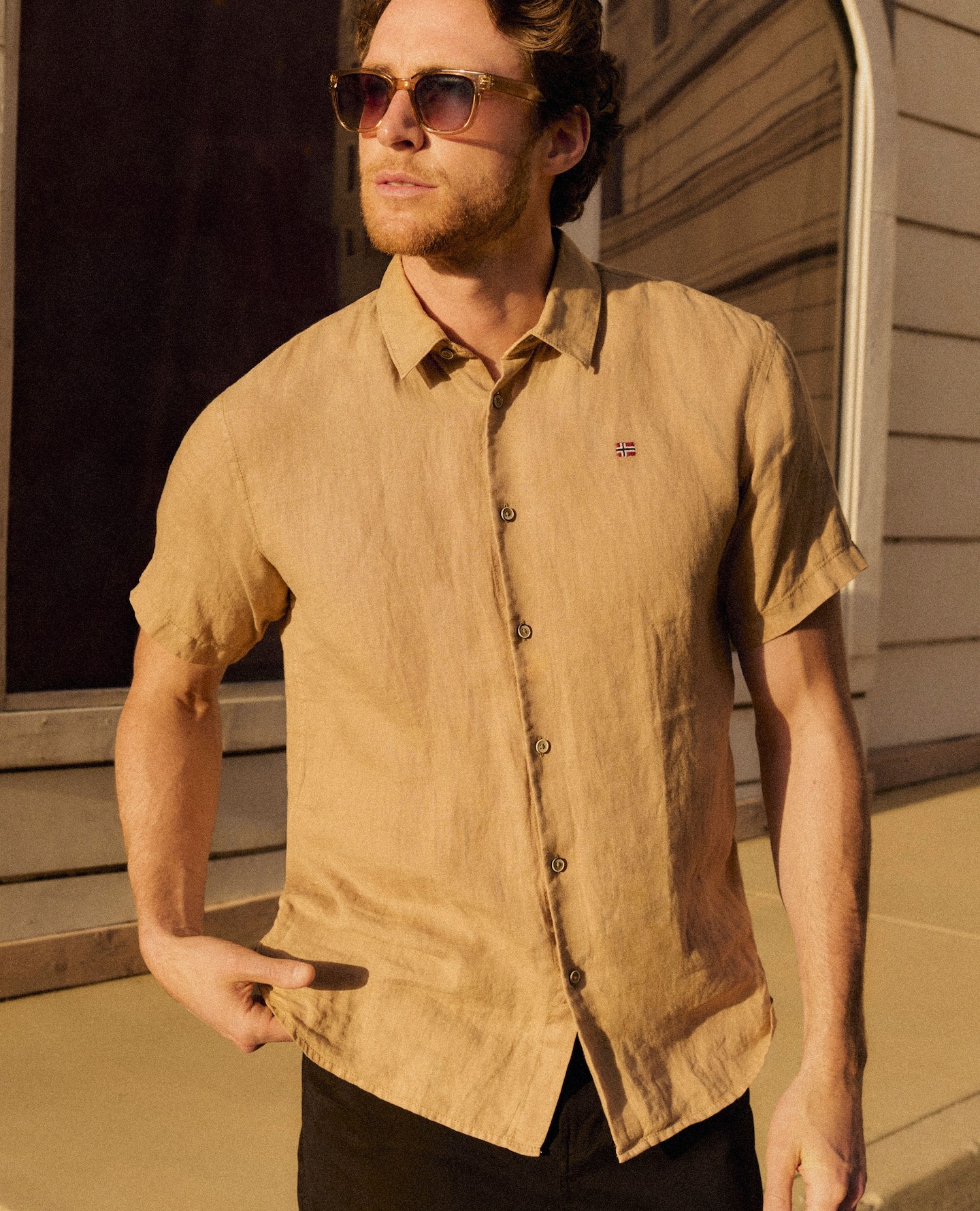Guy wearing a sand coloured napapijri linen shirt on a sun soaked street