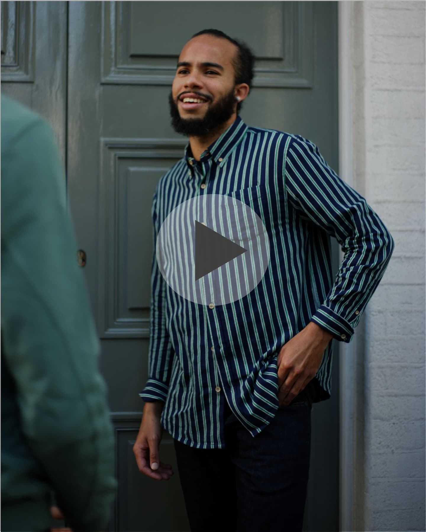 A video still of a man wearing a striped shirt