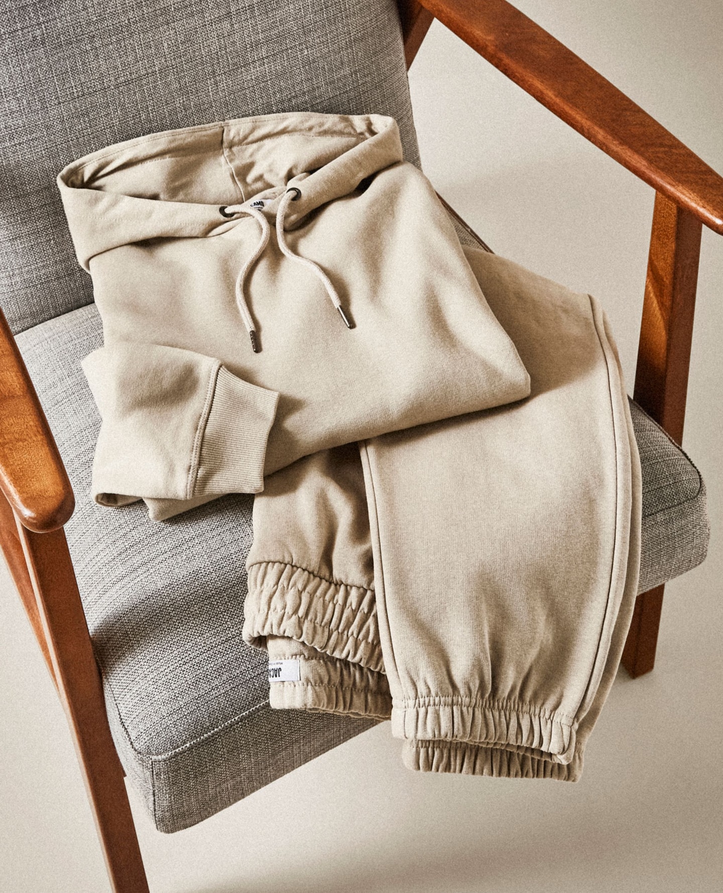 Beige loungewear, hoodie and joggers displayed on chair