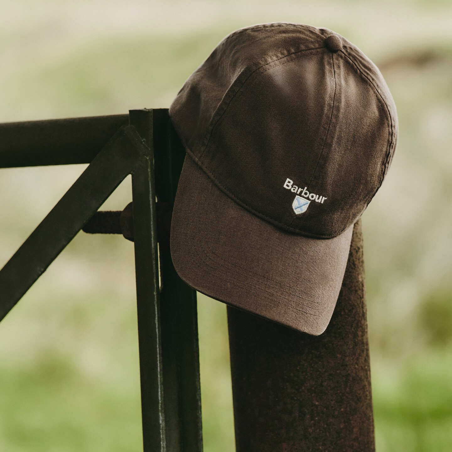 A Barbour cap hung on a gate post