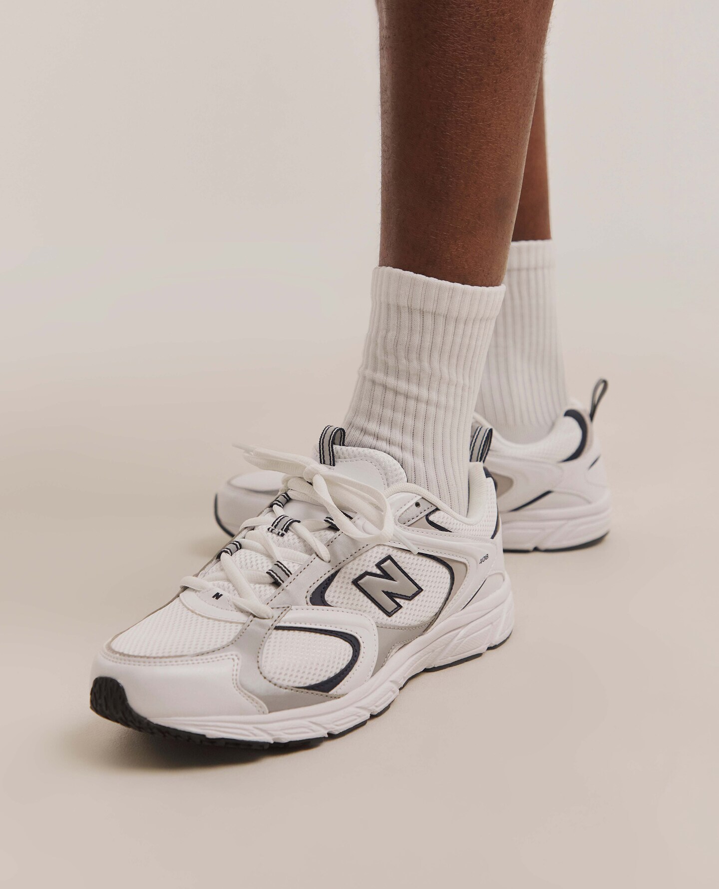 Model wears New Balance 408 Trainers