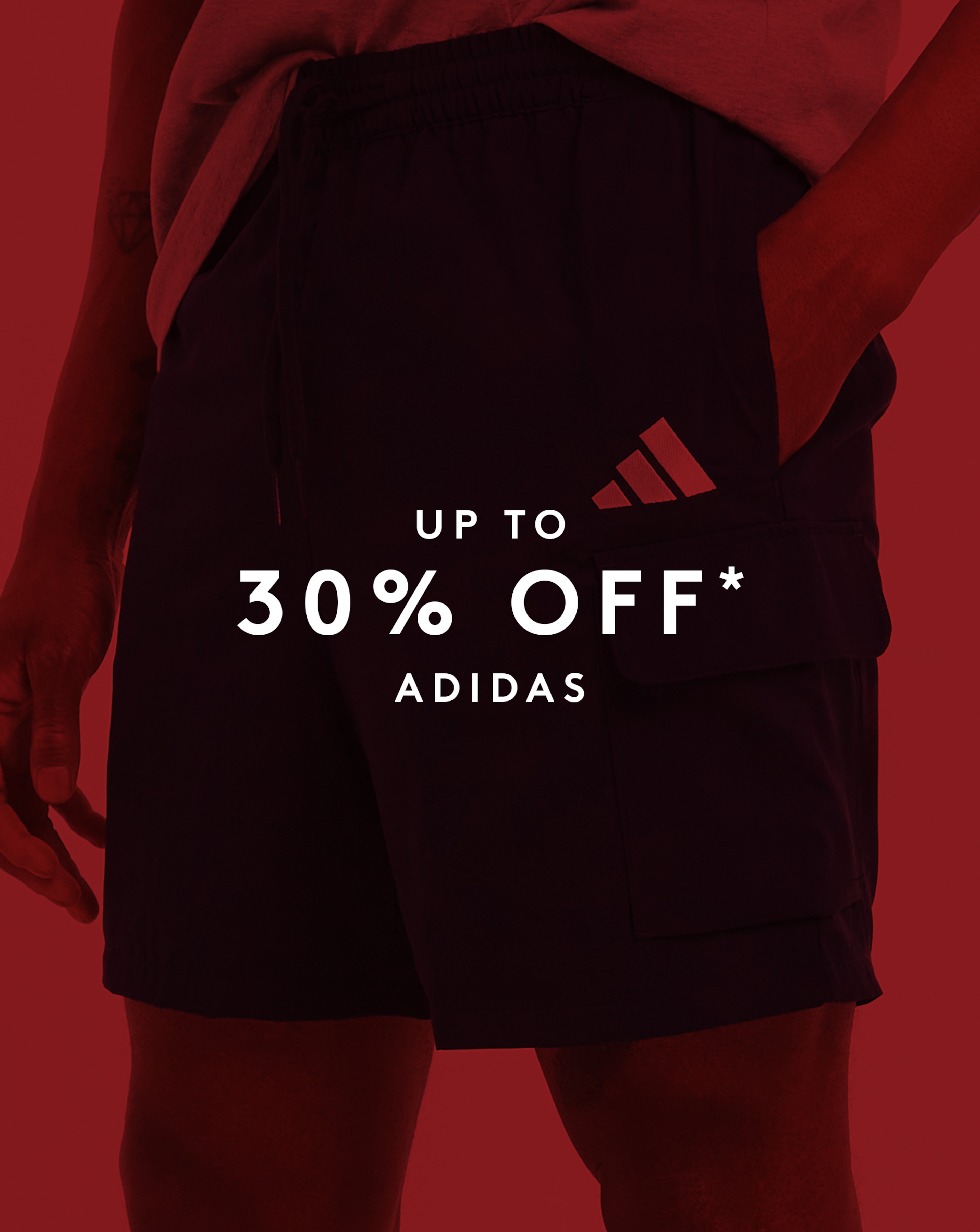 Model wearing adidas shorts with a red sale overlay. Up to 30% off adidas