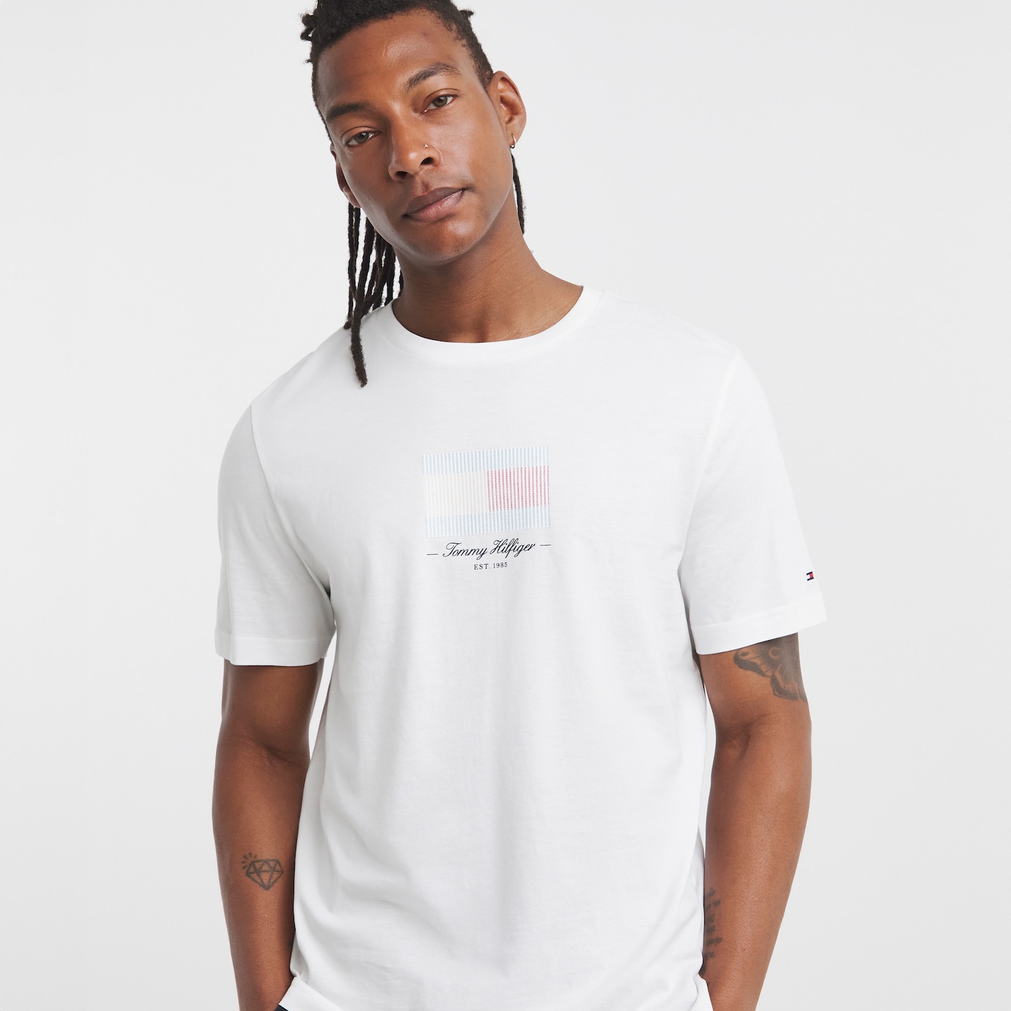 Model wearing a white Tommy Hilfiger t-shirt